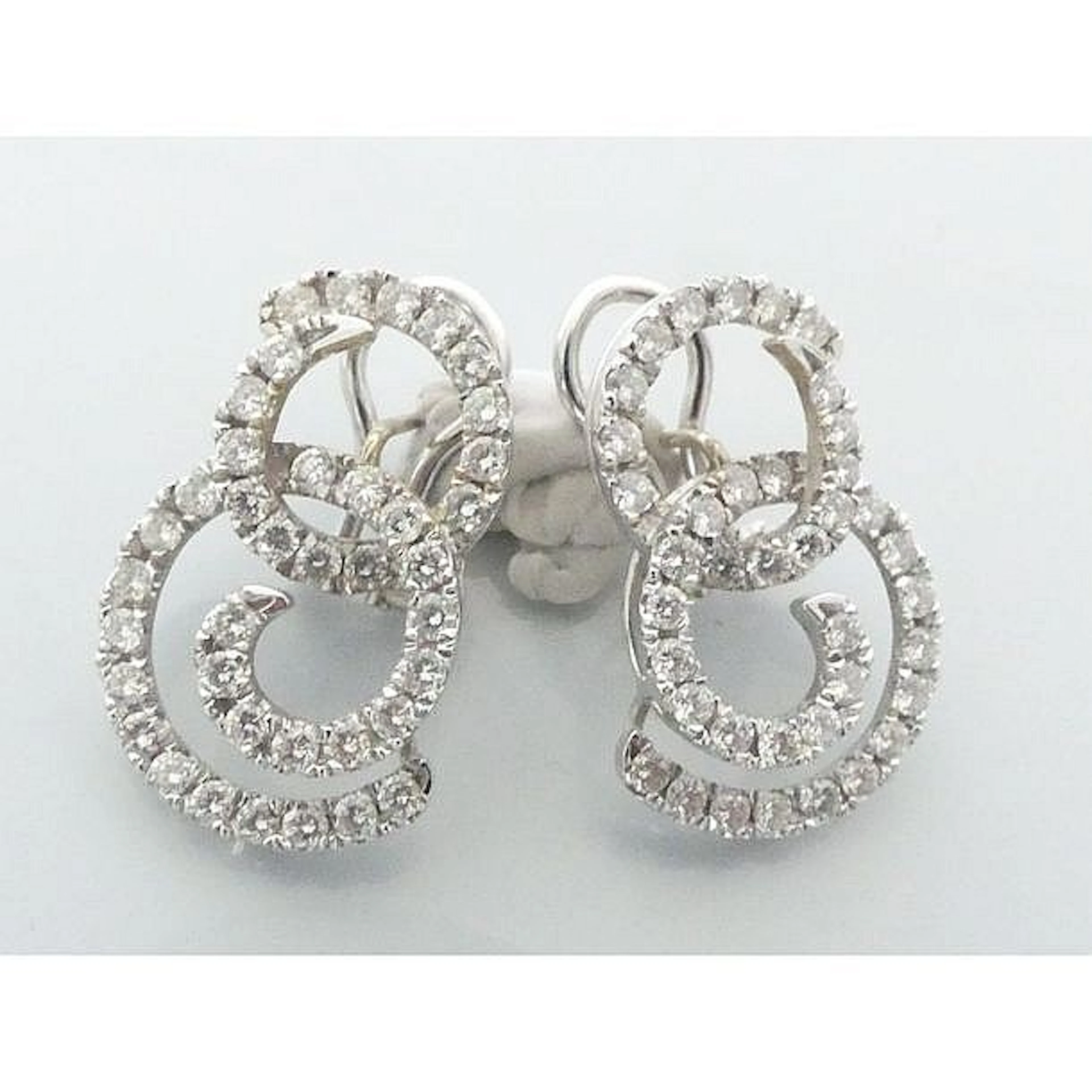 BOUCLES D?OREILLES en or blanc 750°/°° à motif de volutes serties de diaman