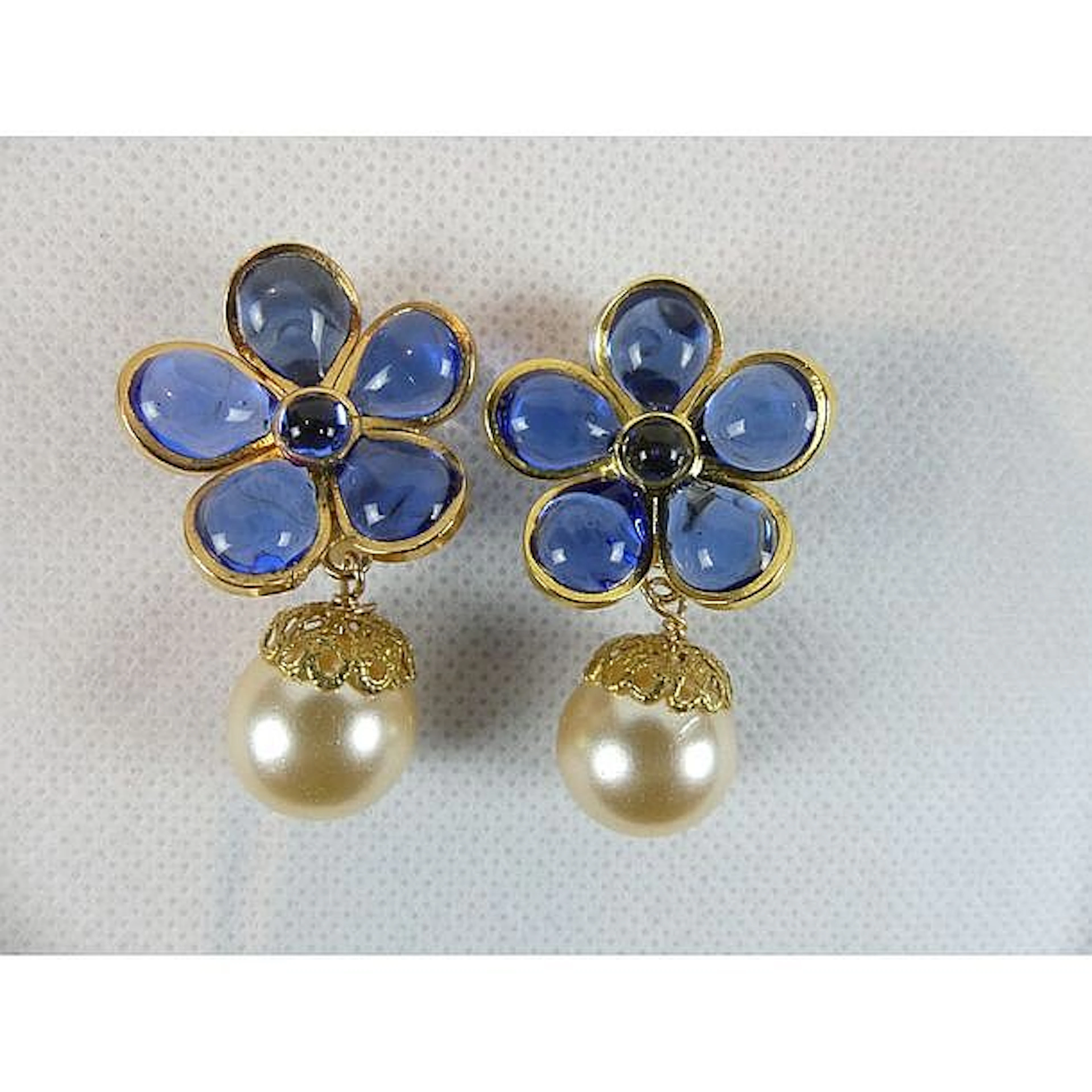 CHANEL. Paire de boucles d?oreilles ornées d?une fleur émaillée bleue agrém