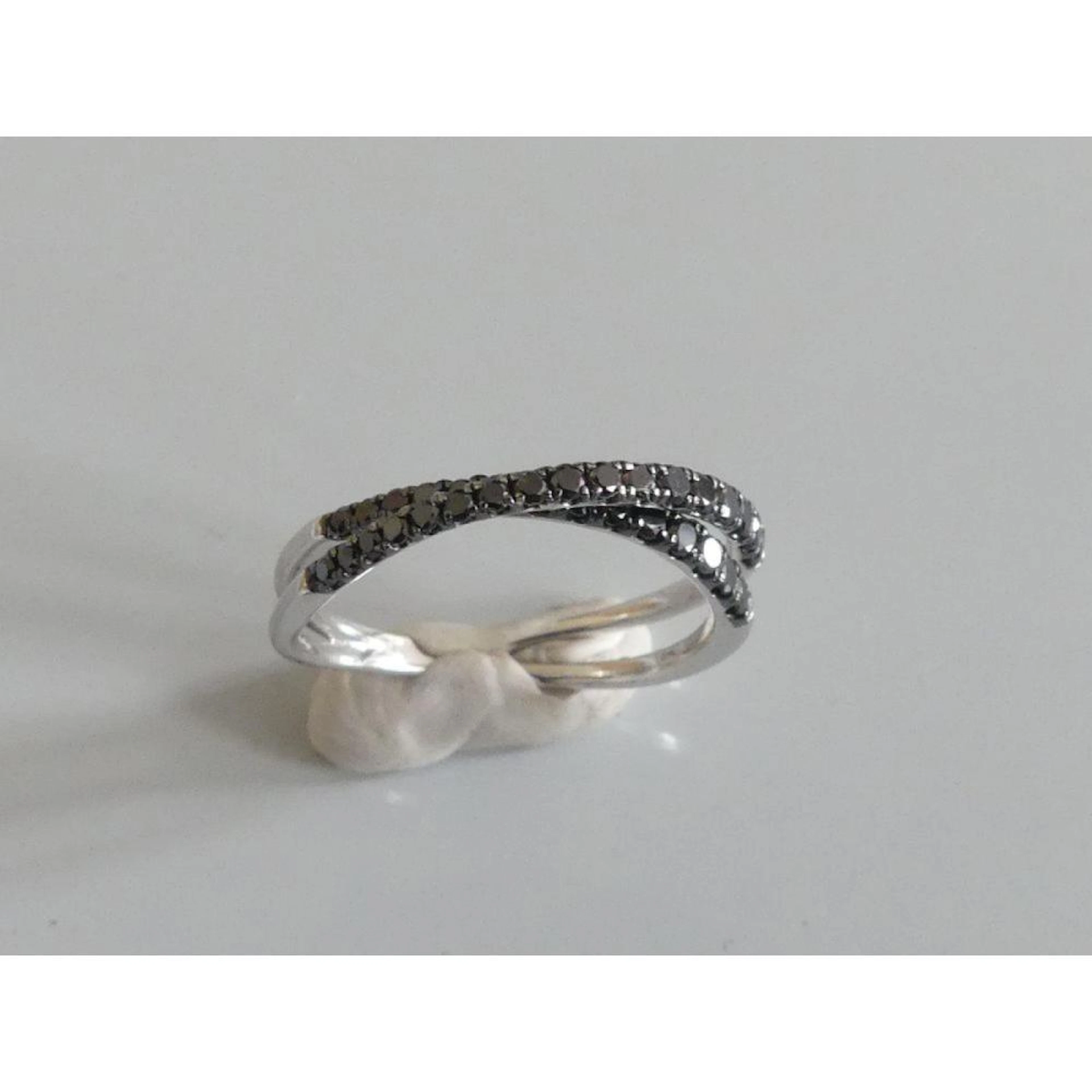 DJULA. Bague 2 joncs en or blanc 750°/°° croisé sertie de diamants noirs