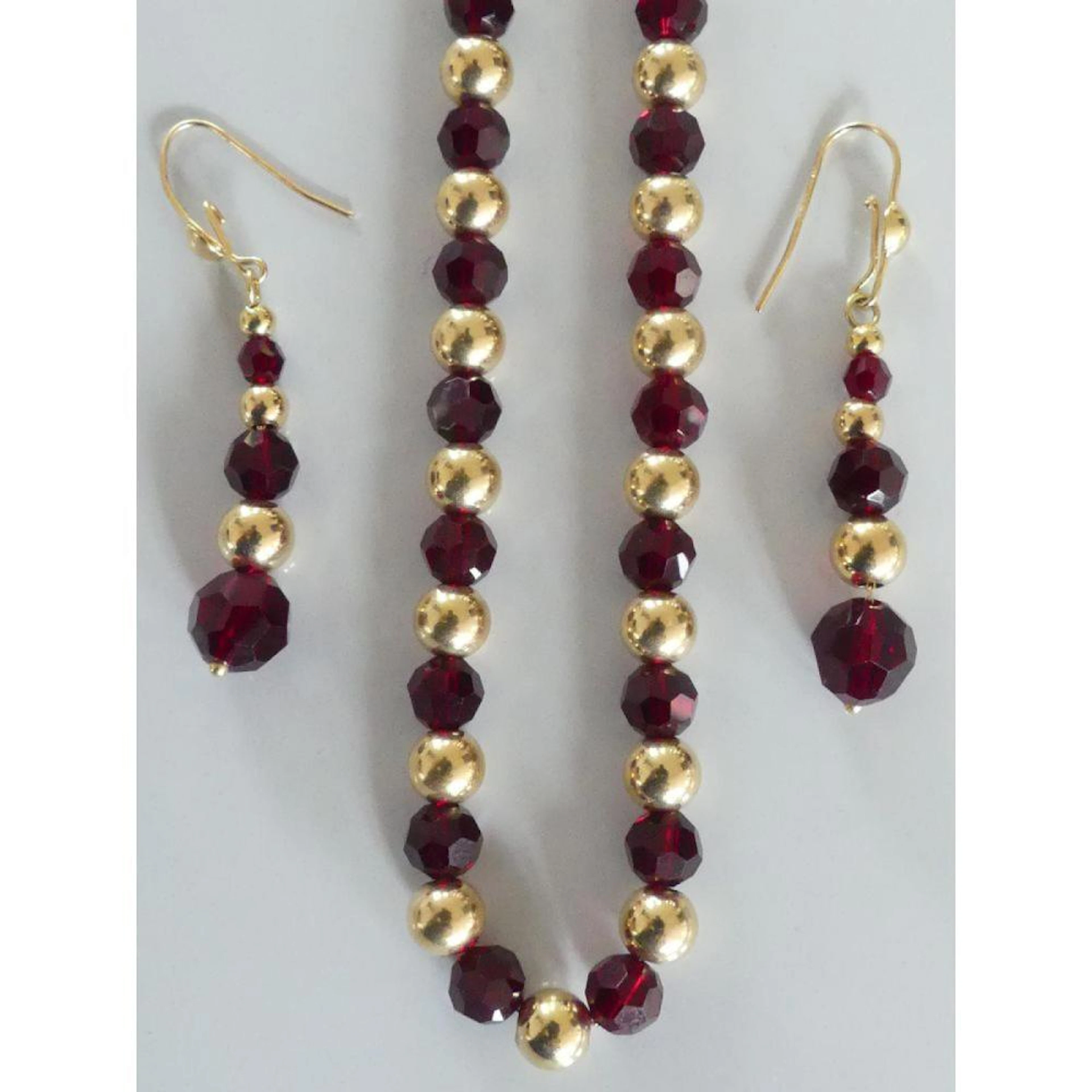 COLLIER de perles de verre grenat intercalées de boules d?or