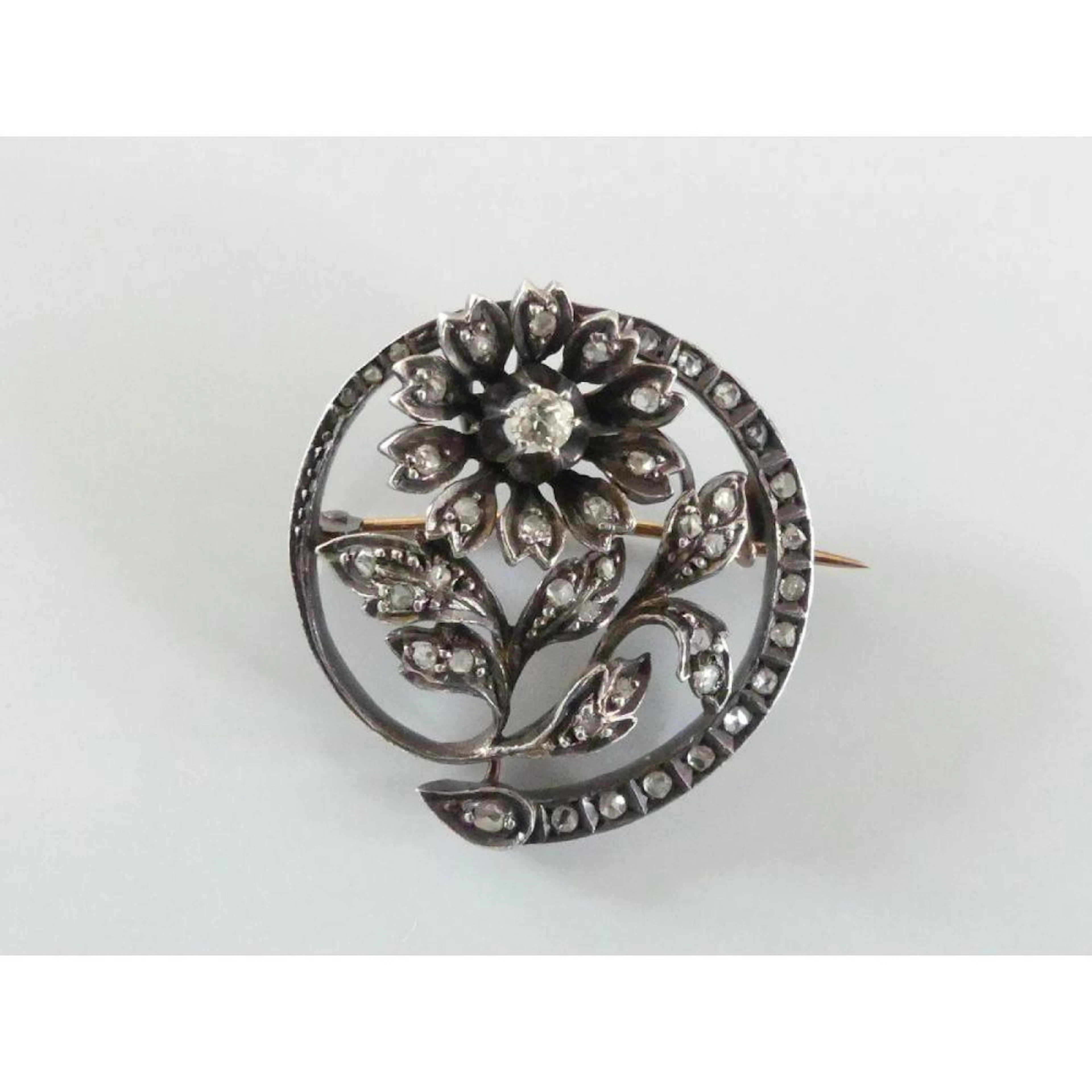 BROCHE ronde en argent et or 750°/°° ornée d?une fleur...
