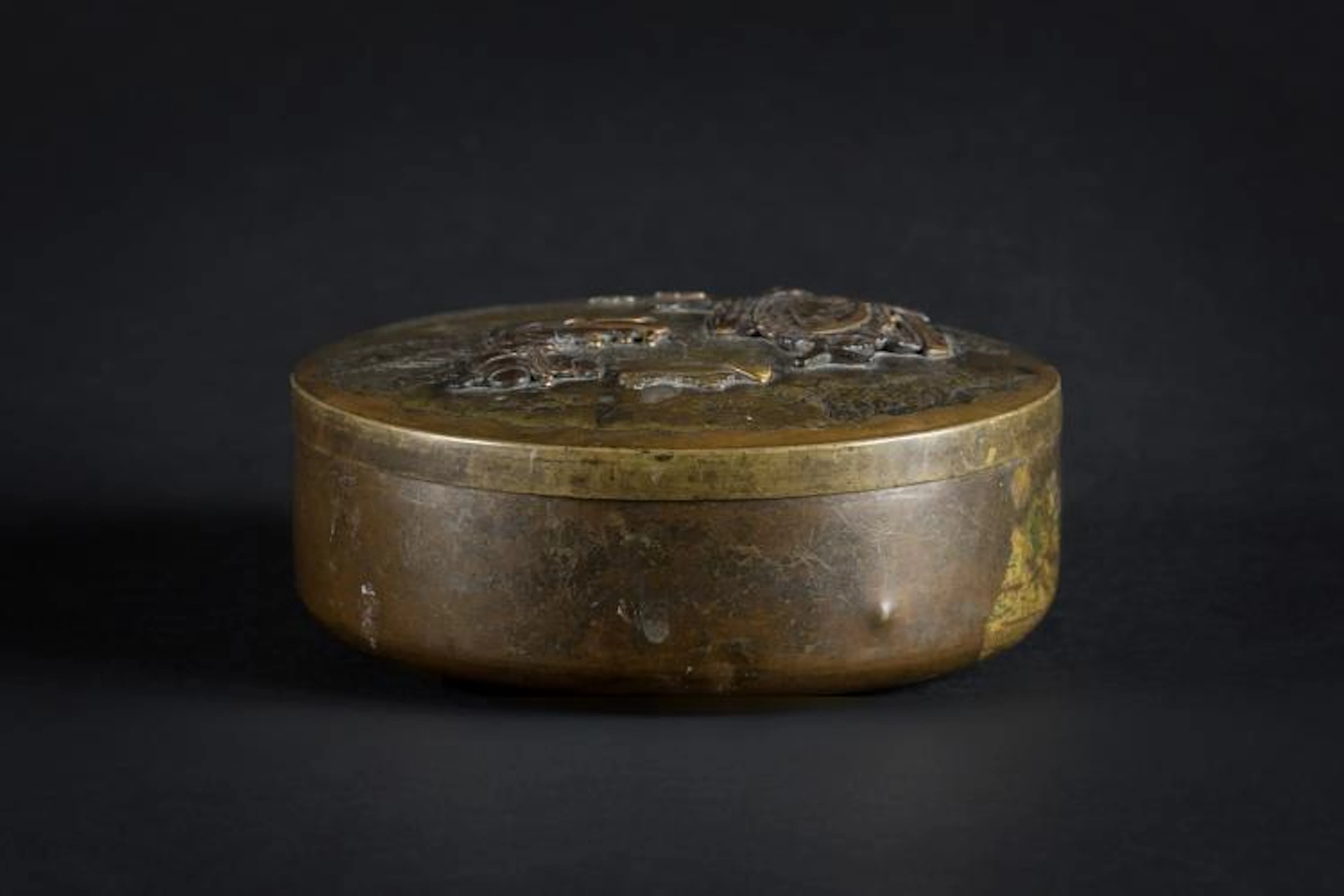 Arte Giapponese A circular brass box and cover decorated...