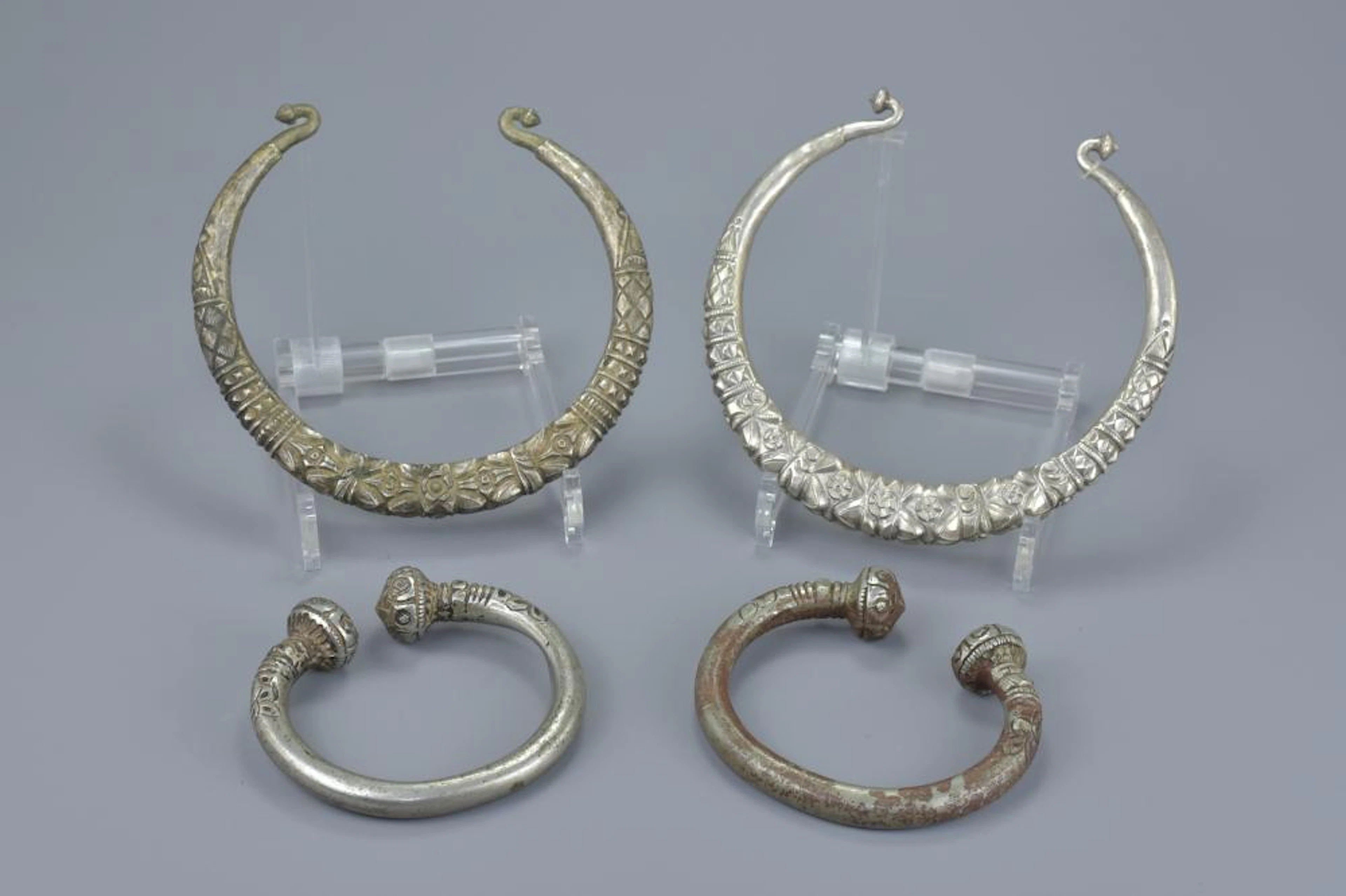 TWO EASTERN WHITE METAL TORQUE / TORC NECKLACE TOGETHER WITH