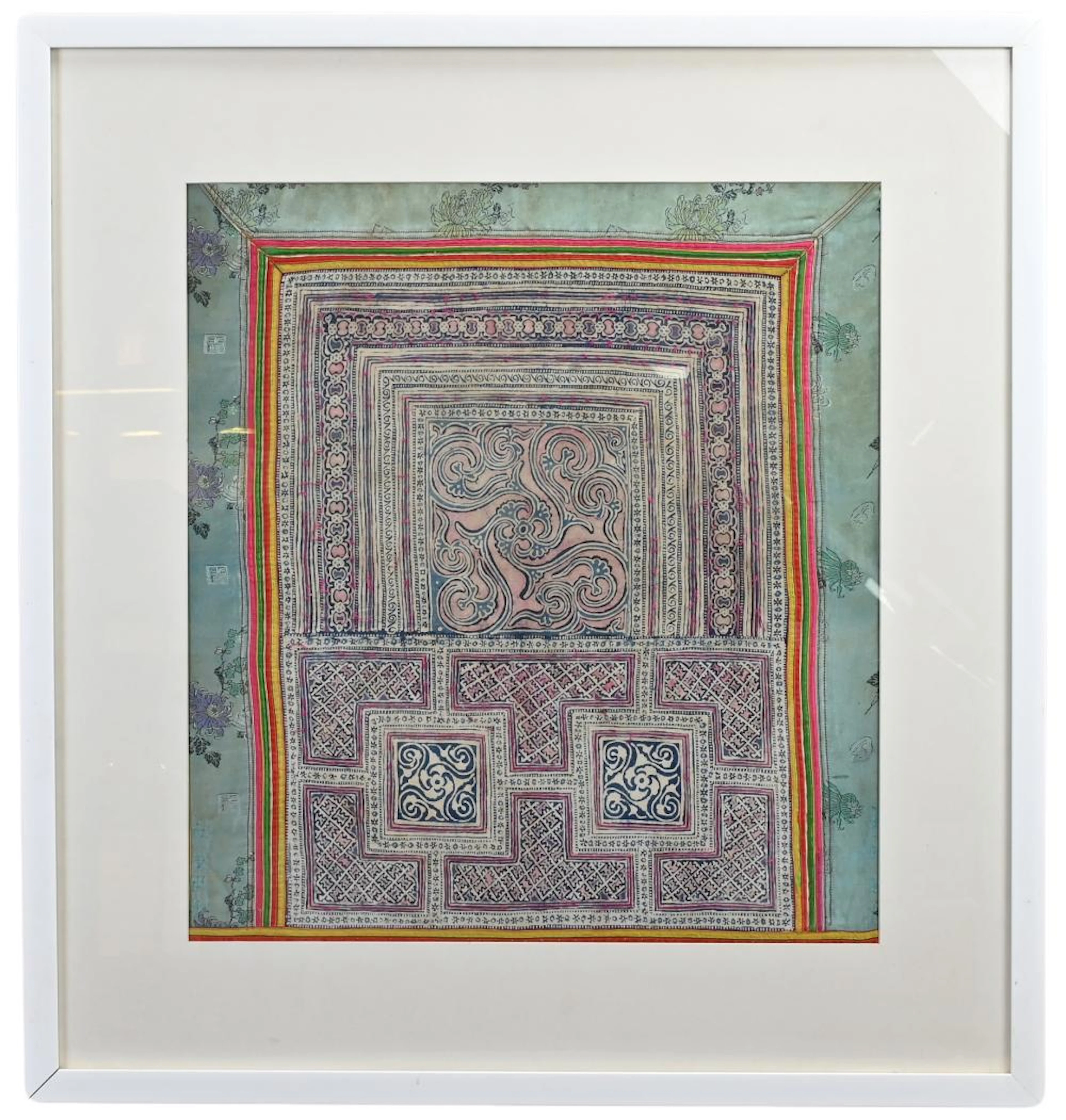 A FRAMED VINTAGE COTTON WOODBLOCK PRINT WITHIN CHINESE SILK BORDER
