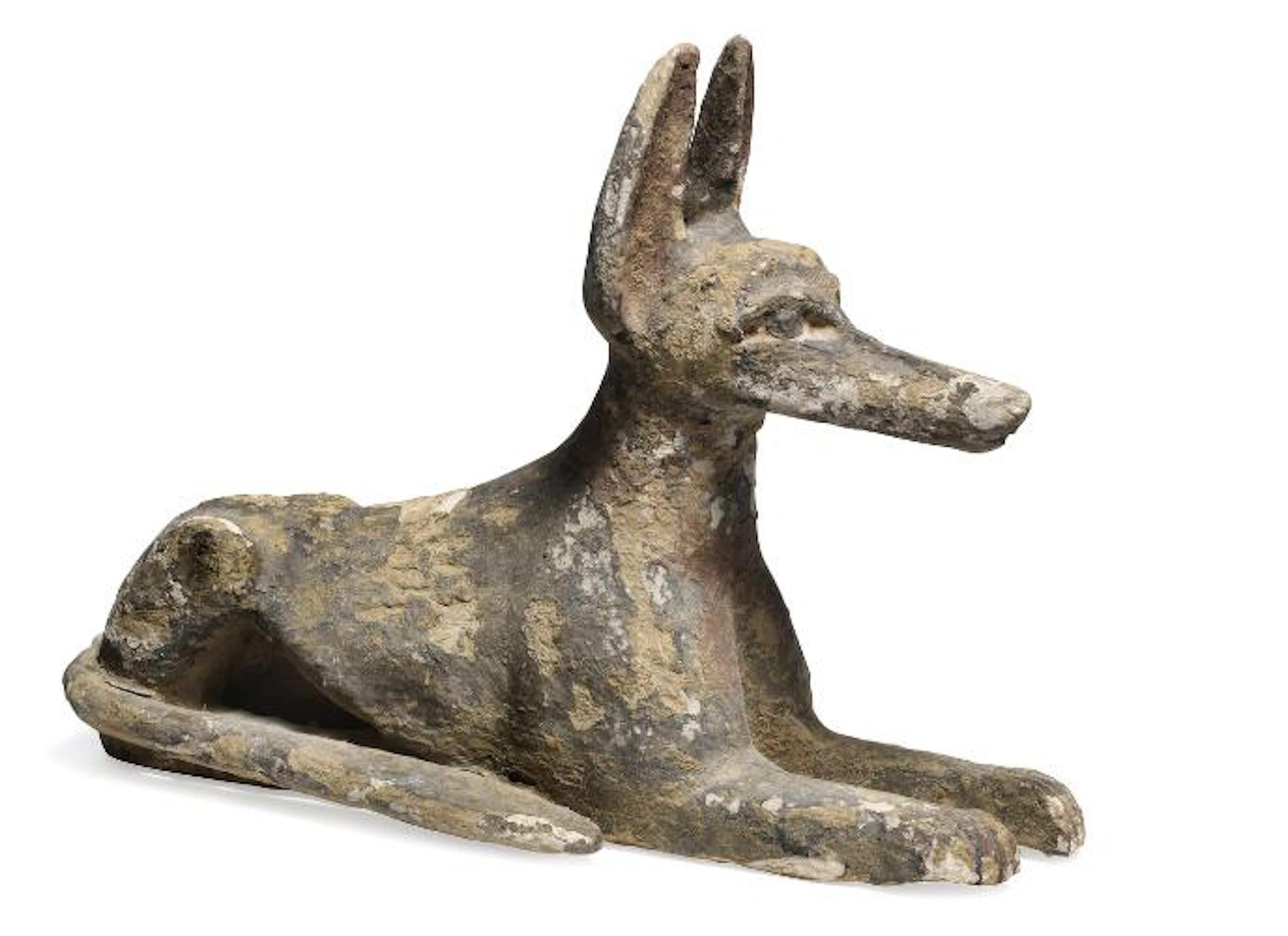An Egyptian wood jackal figure lying in guard with straight forelegs