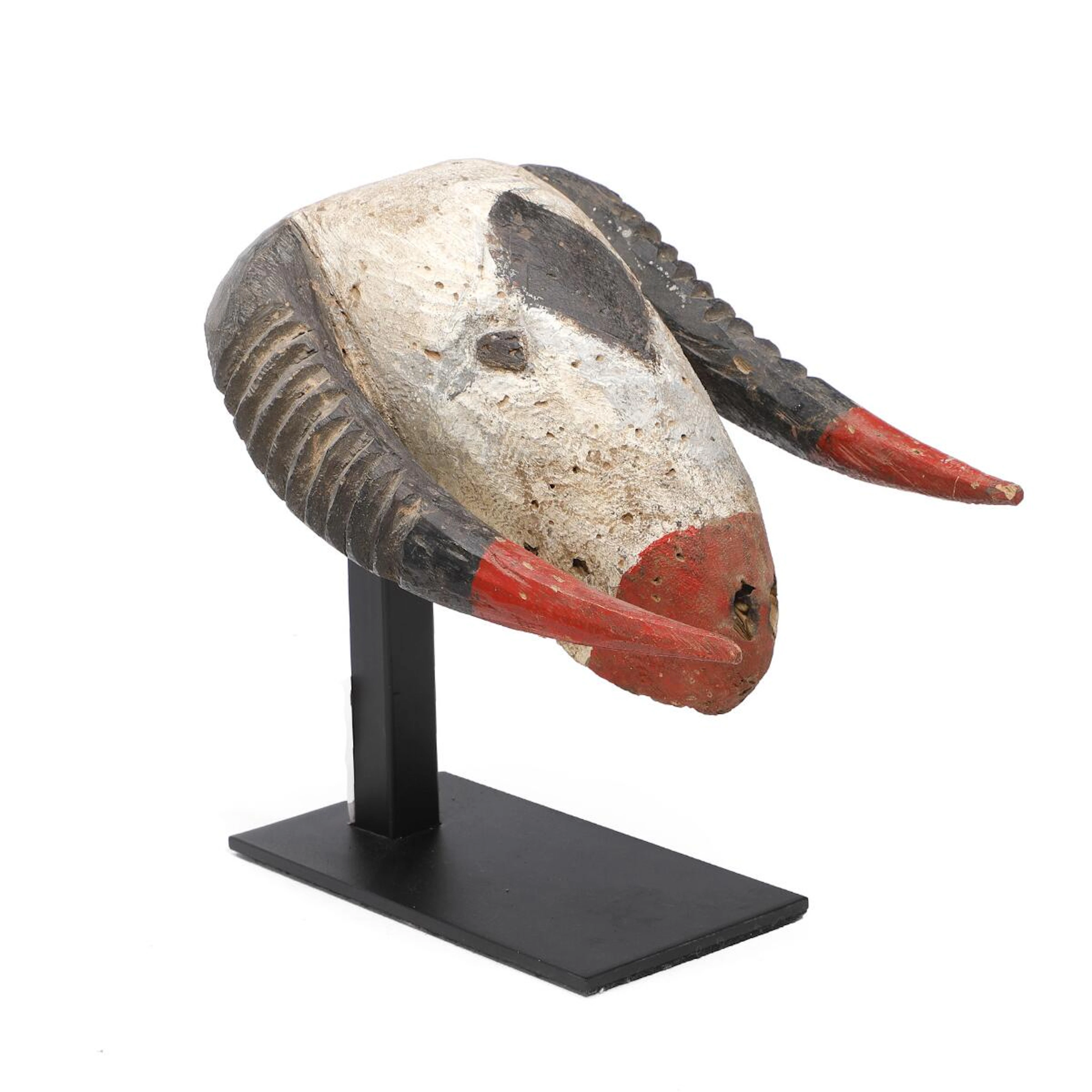 Afrikansk maske af udskåret og bemalet træ. På stand. H. stand 27 cm.
