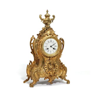 A French Rococo style gilt bronze mantel clock with white...