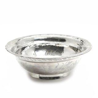 A silver bowl richly decorated with flowers and foliage