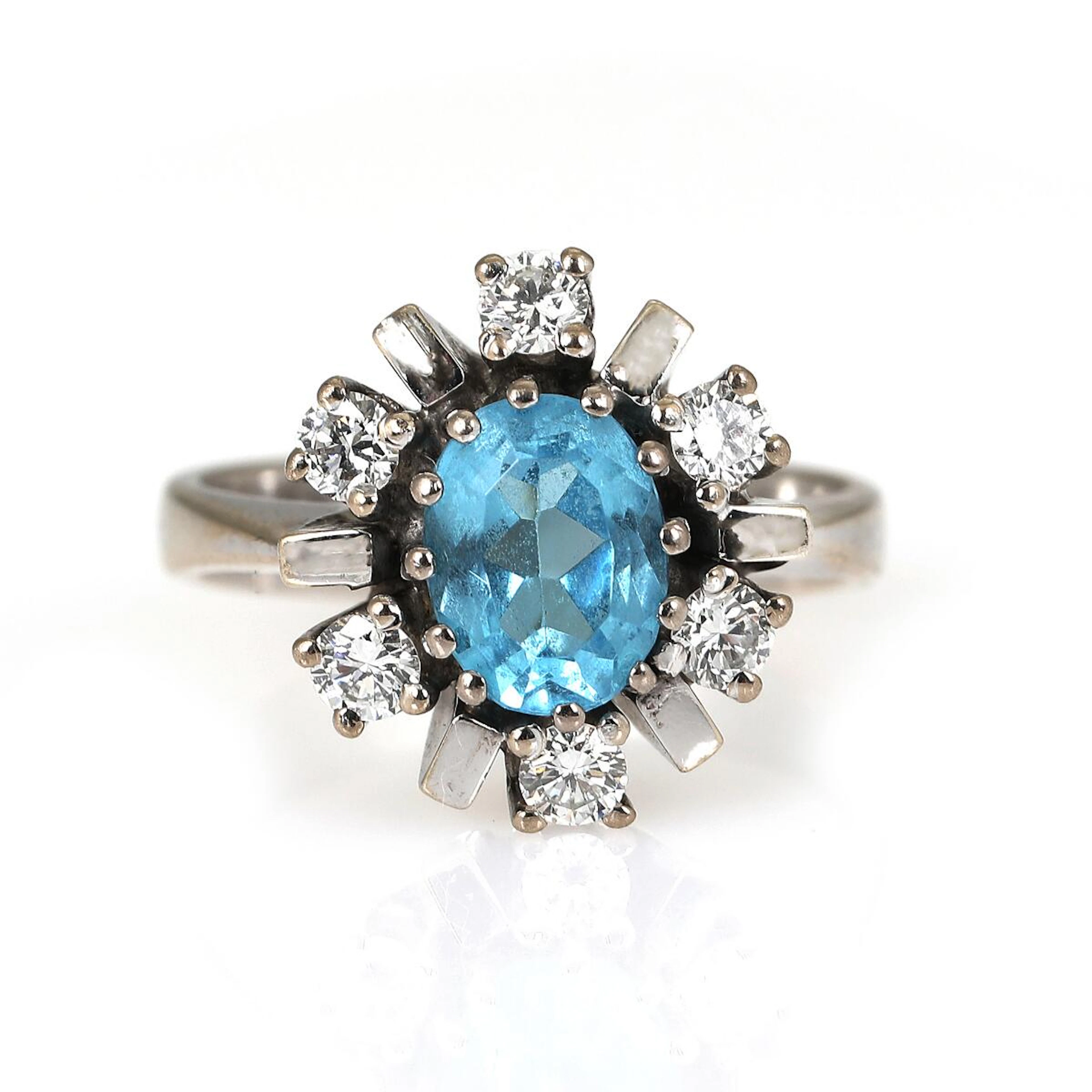 A diamond ring set with an oval-cut syntetic spinel...