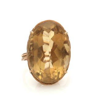 A citrine ring set with a faceted citrine, mounted in 14k gold. Size