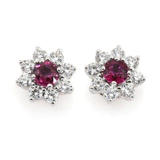 A pair of ruby and diamond ear studs each set with a ruby encircled