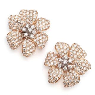 A pair of diamond ear studs in the shape of a flower each set with