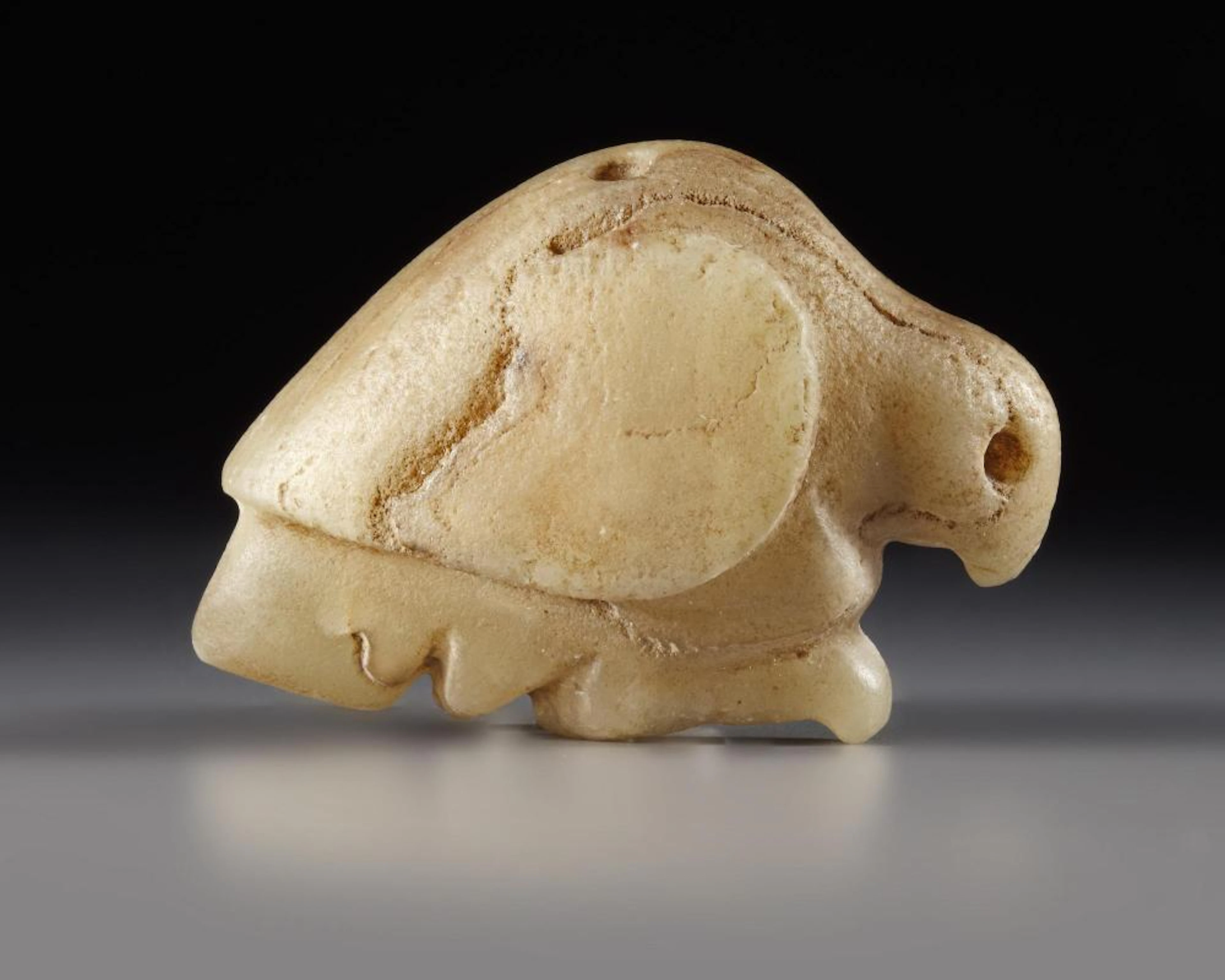 A WESTERN ASIATIC MARBLE SEAL AMULET IN THE FORM OF A BIRD OF PREY