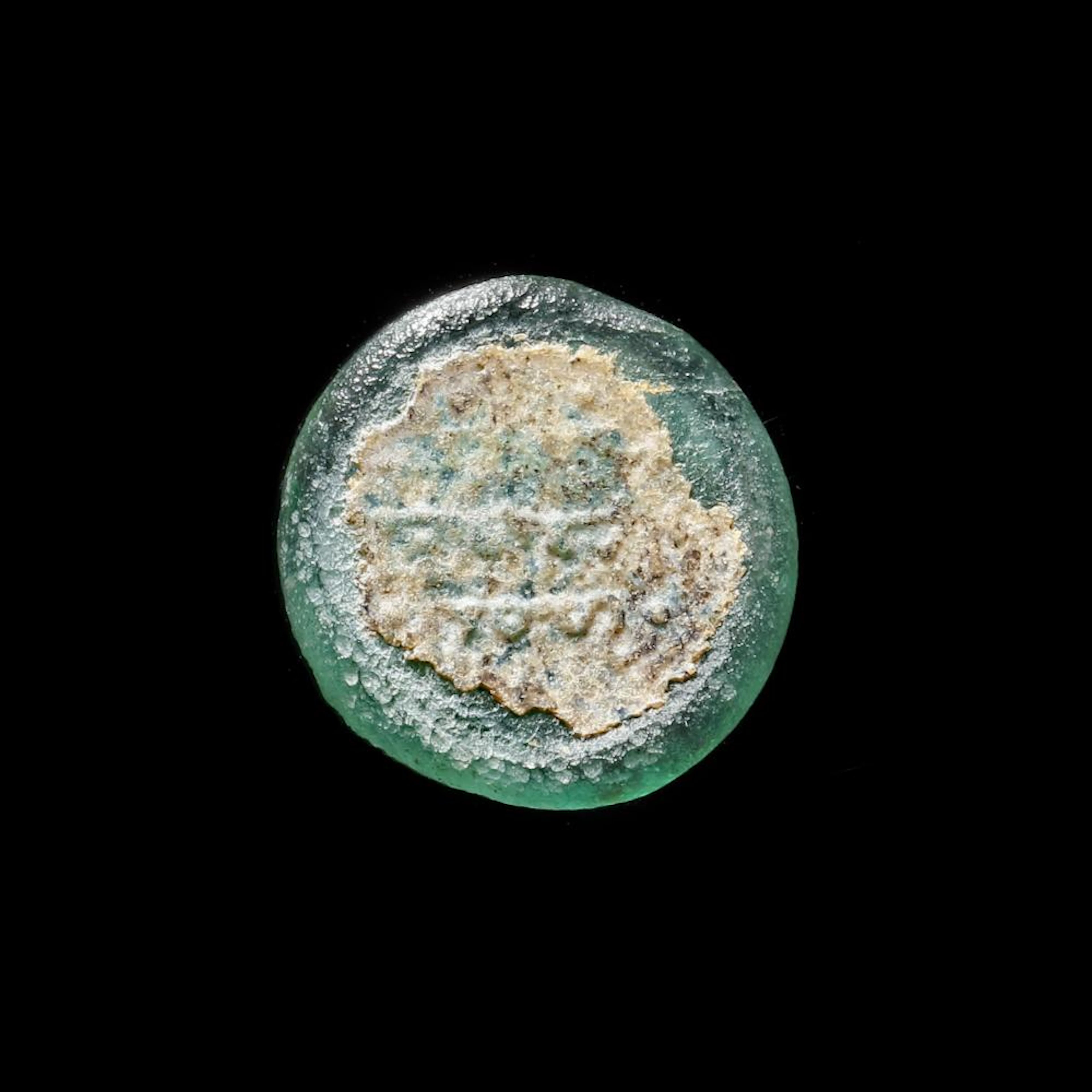 A FATIMID GLASS WEIGHT OF HALF DINAR