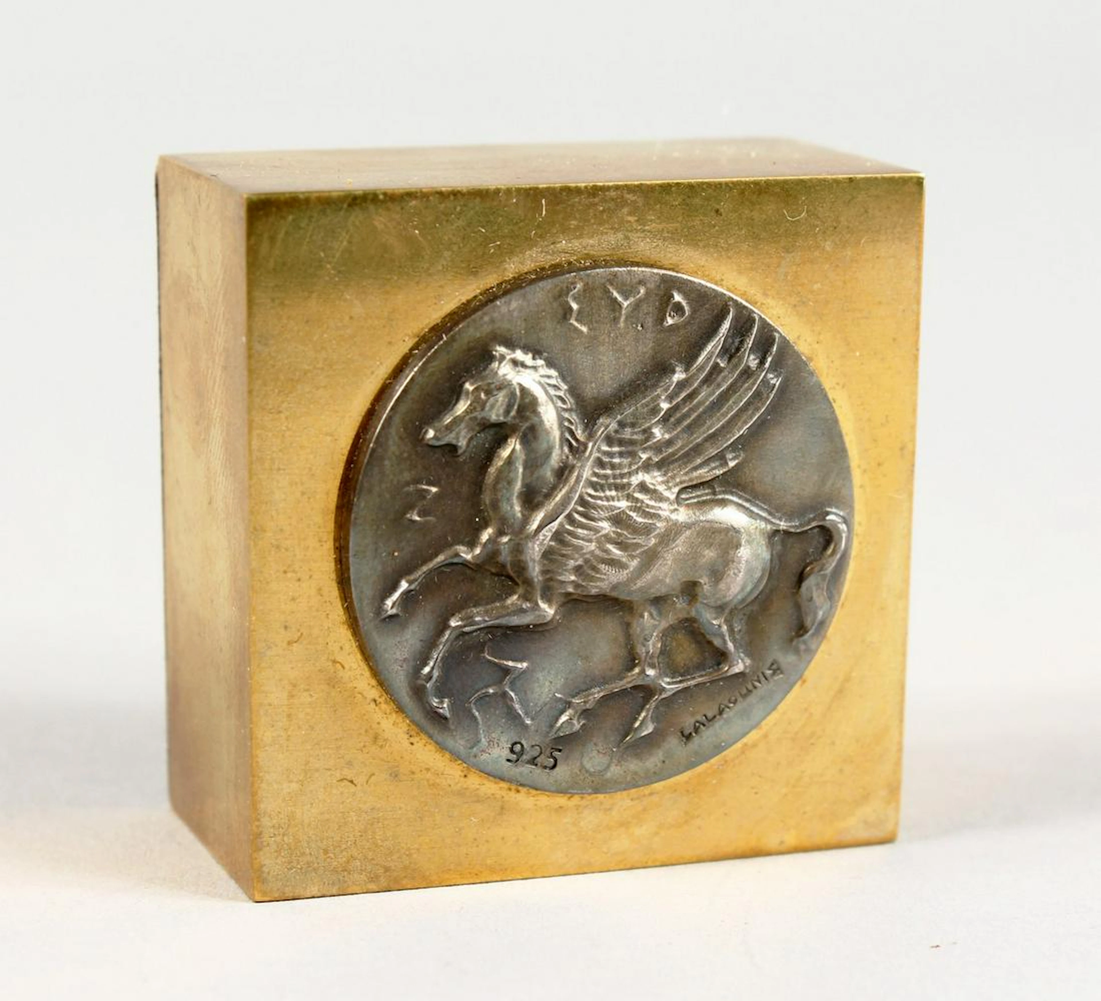 A LALOUNIS FLYING HORSE WEIGHT in a blue Lalounis box.