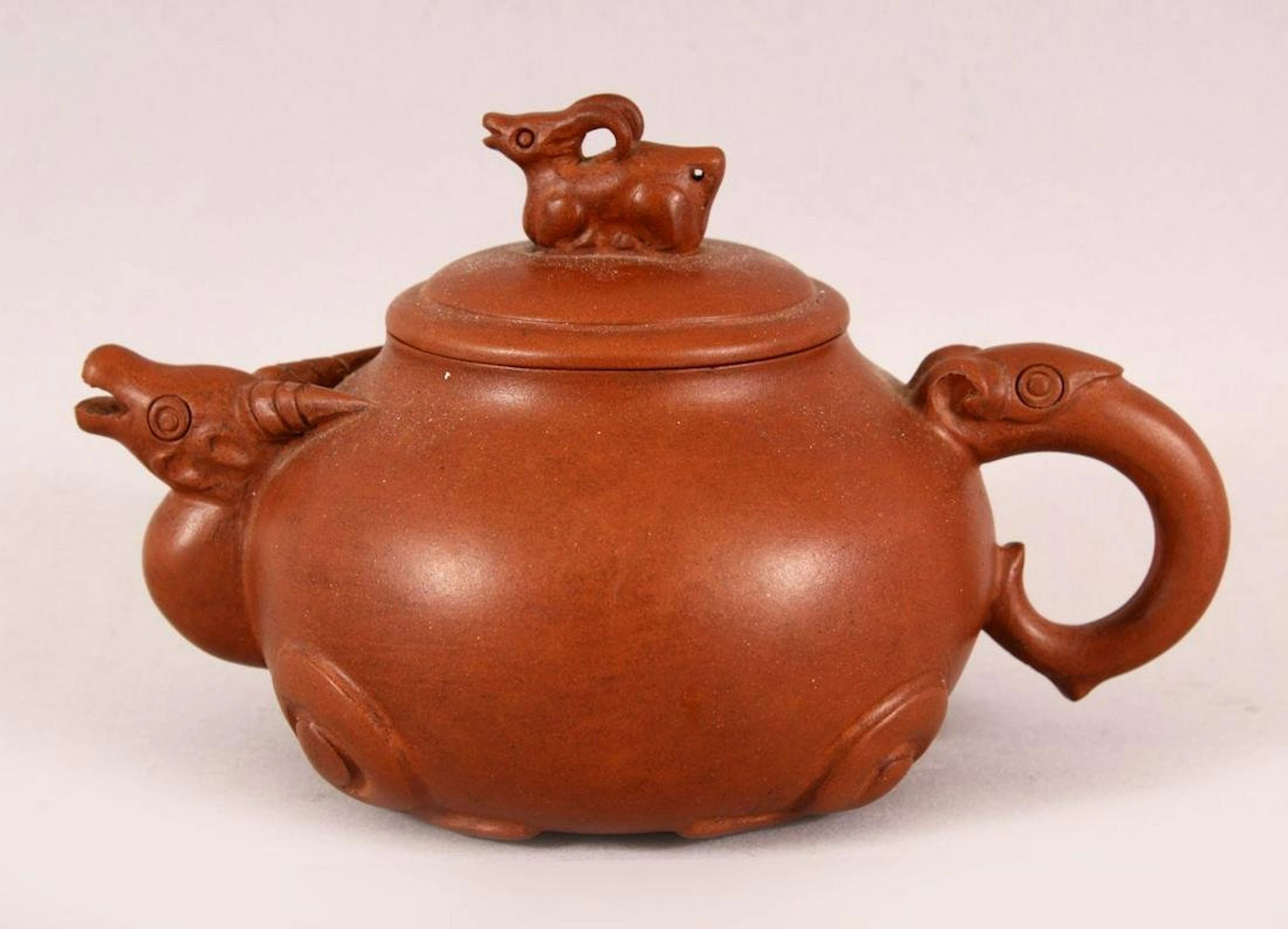 A CHINESE YIXING CLAY RAMS HEAD TEAPOT, in the form of