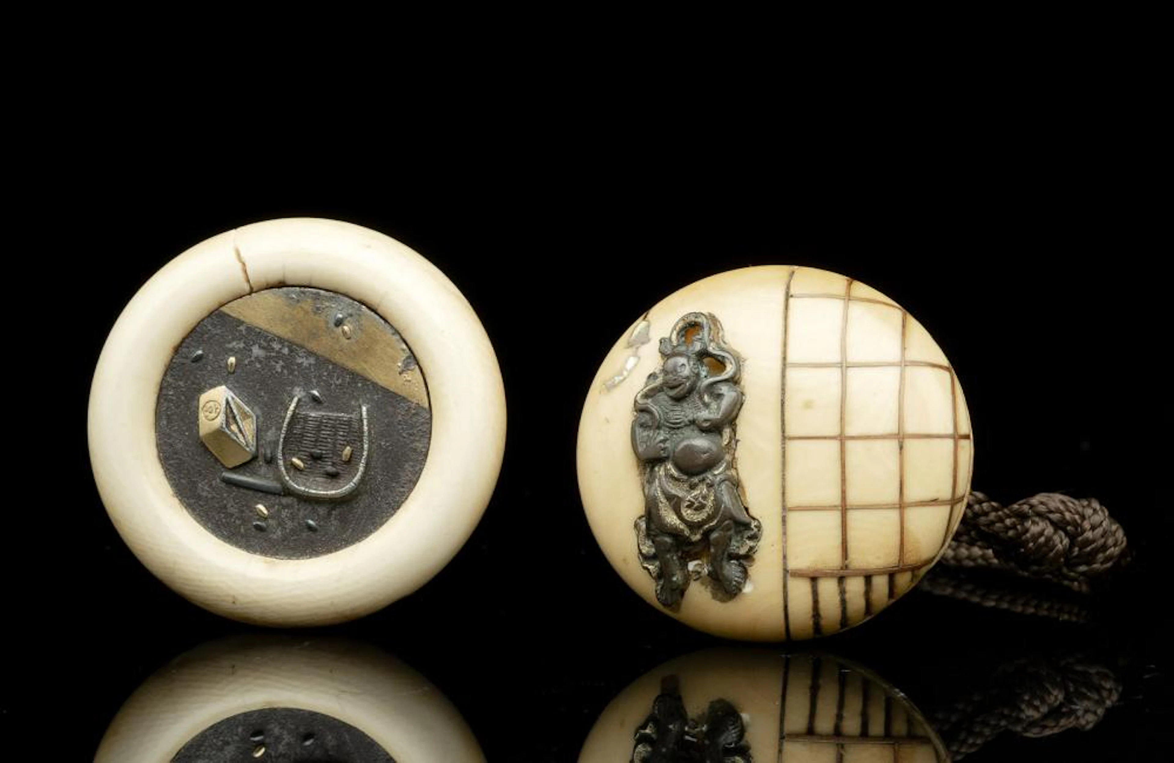 AN IVORY MANJU WITH IRON PLACQUE DECORATED WITH...