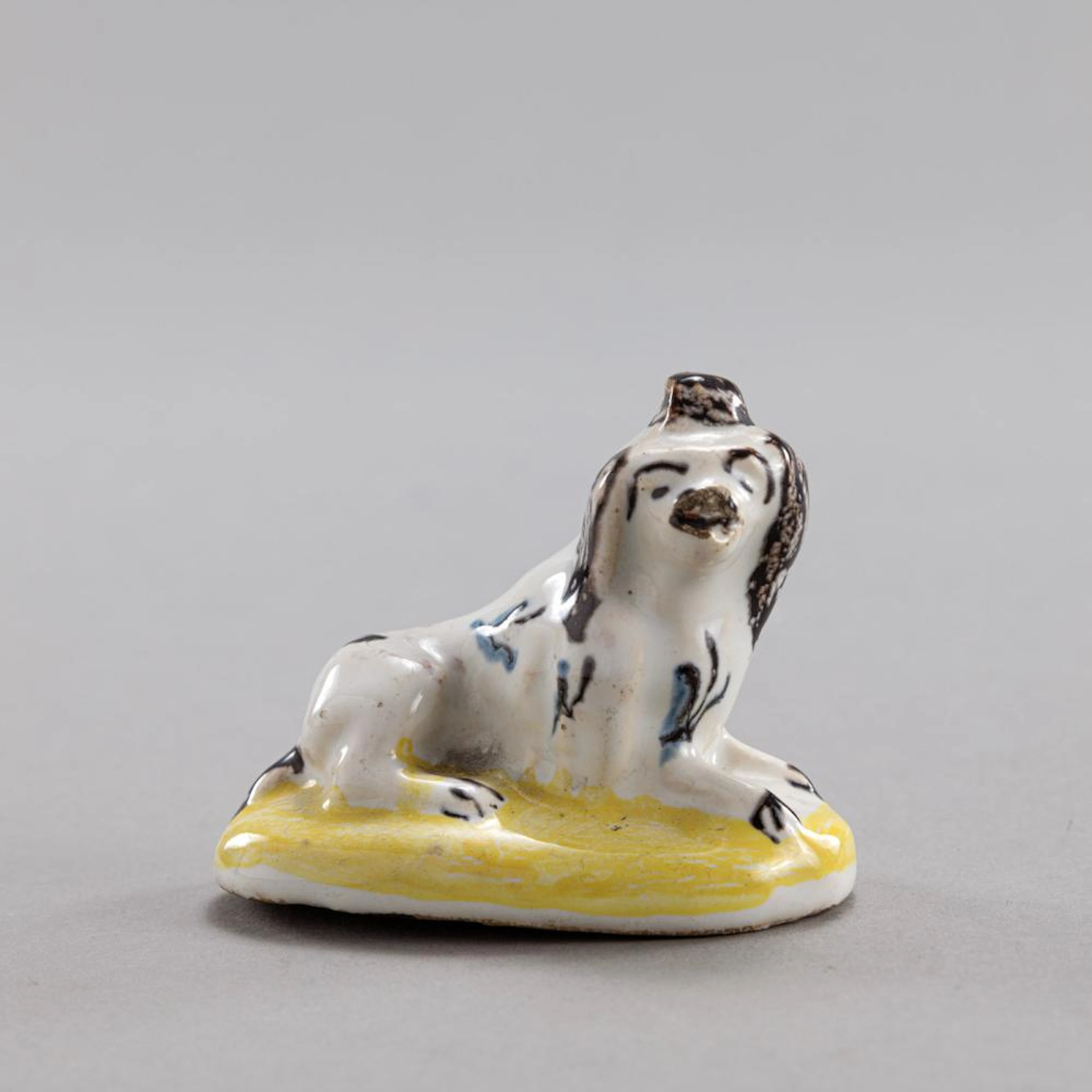 A CONTINENTAL FAYENCE MODEL OF A SPANIEL