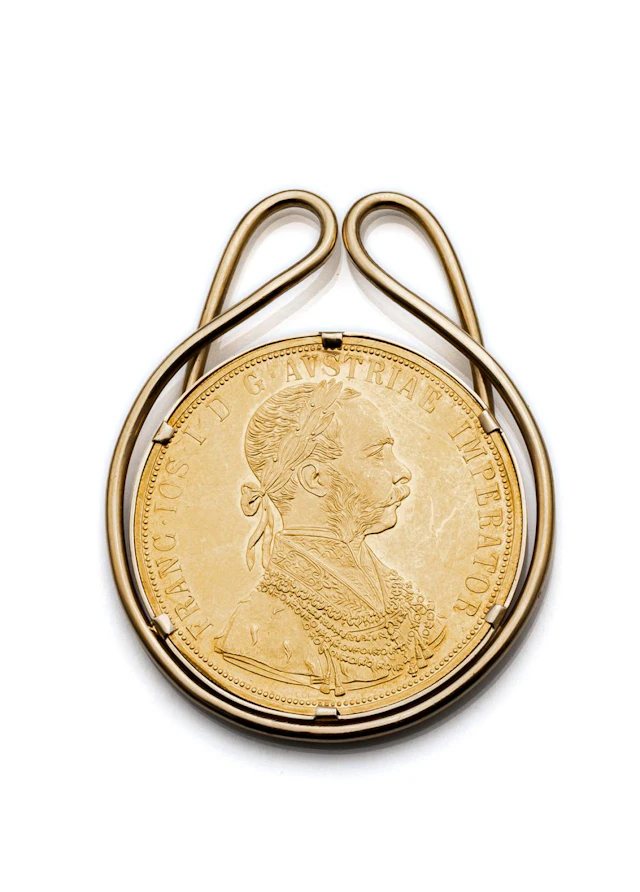Goldmünze als Papier-Clip gefasst