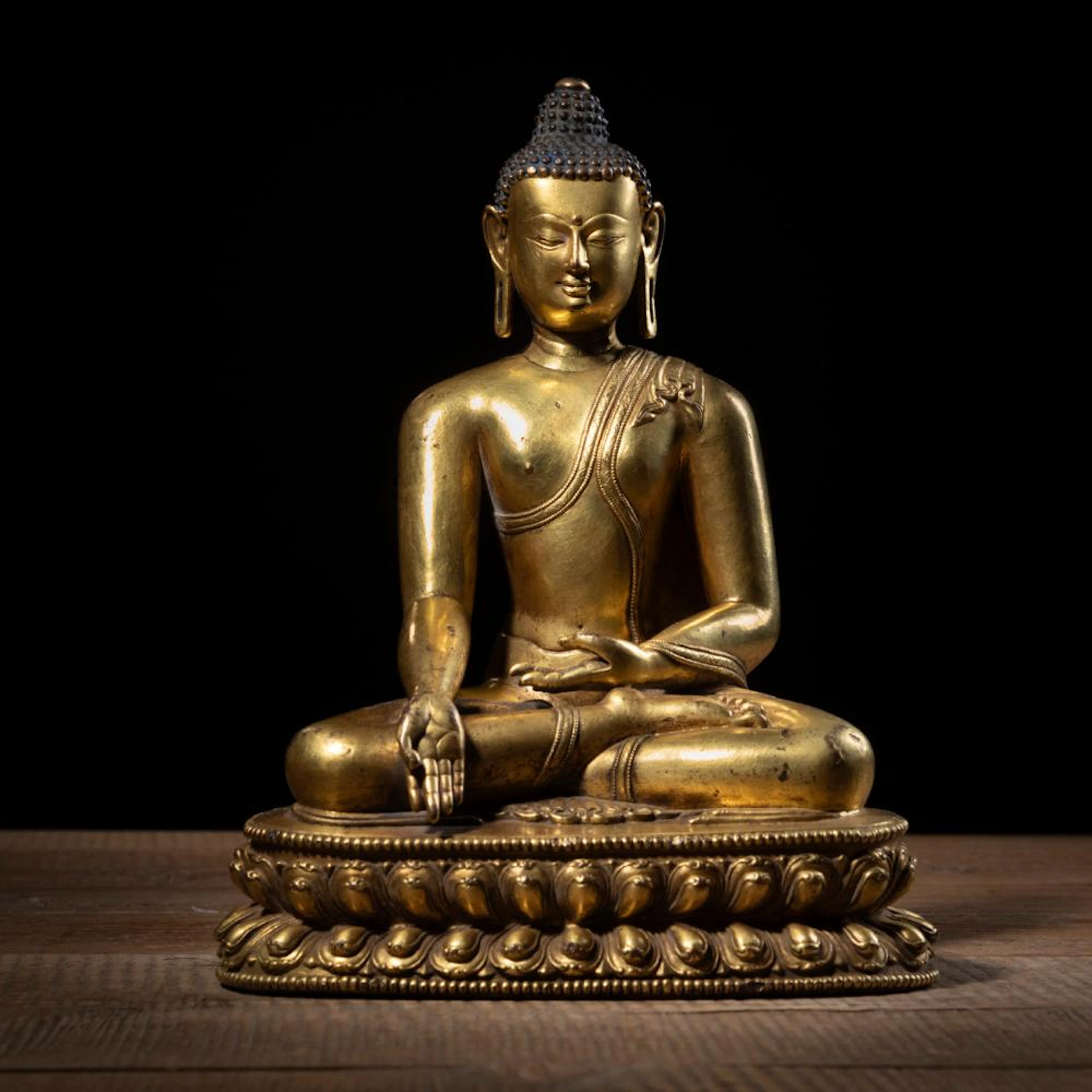 A GILT-BRONZE BUDDHA SHAKYAMUNI SEATED ON A LOTUS