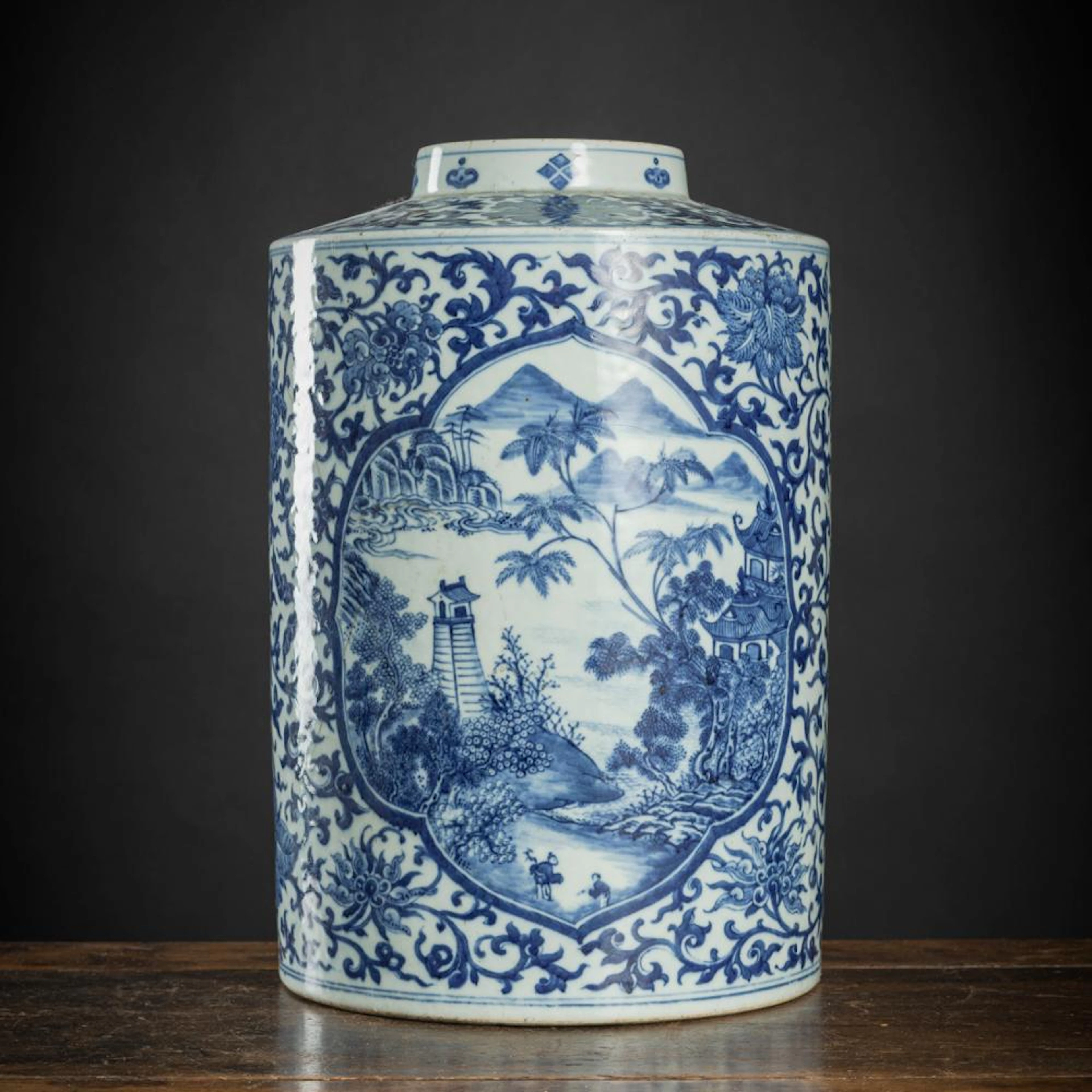 A CYLINDRICAL BLUE AND WHITE LOTUS AND LANDSCAPE PORCELAIN VESSEL