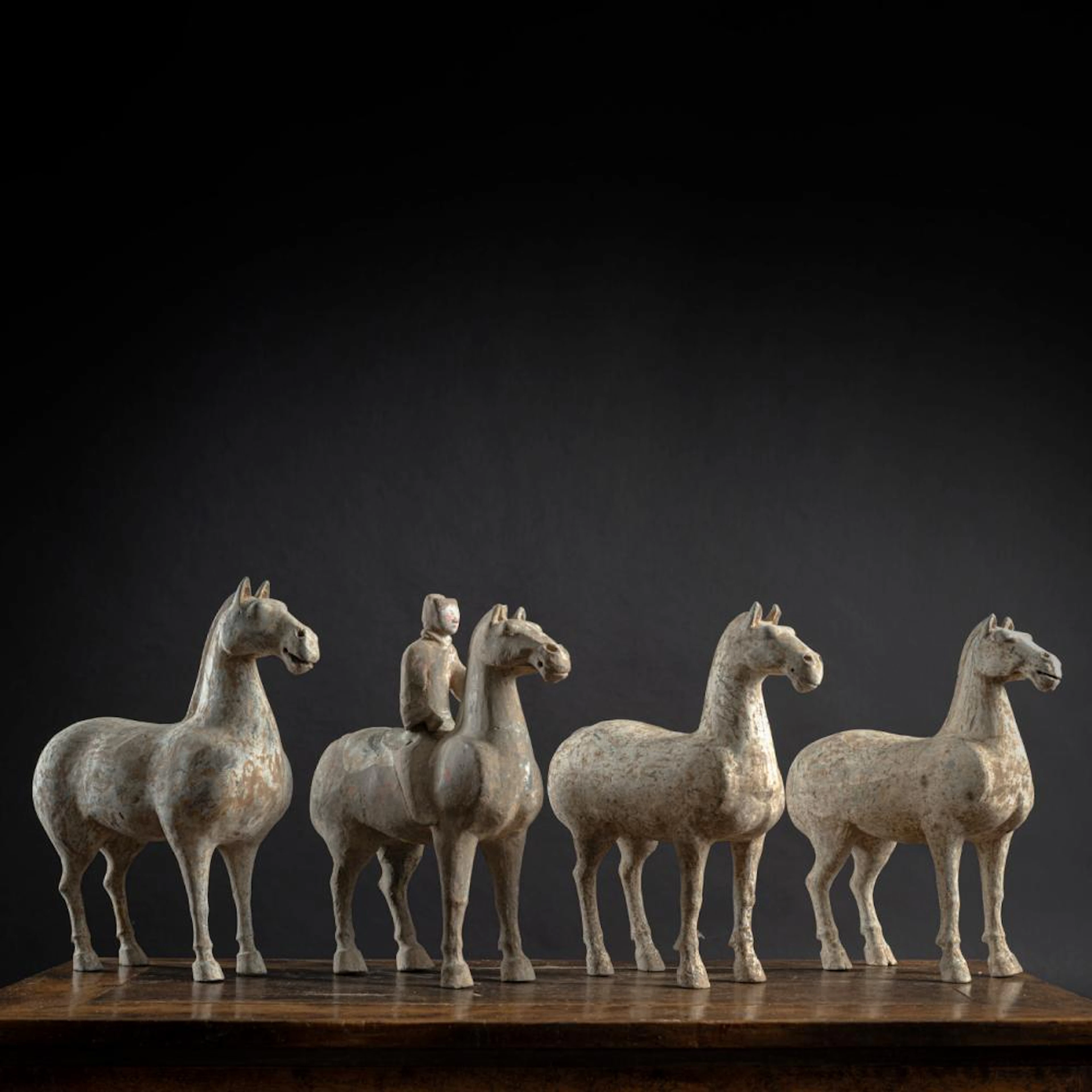 THREE POTTERY HORSES AND A HORSE WITH RIDER WITH RESIDUE OF POLYCHROME PAINTING