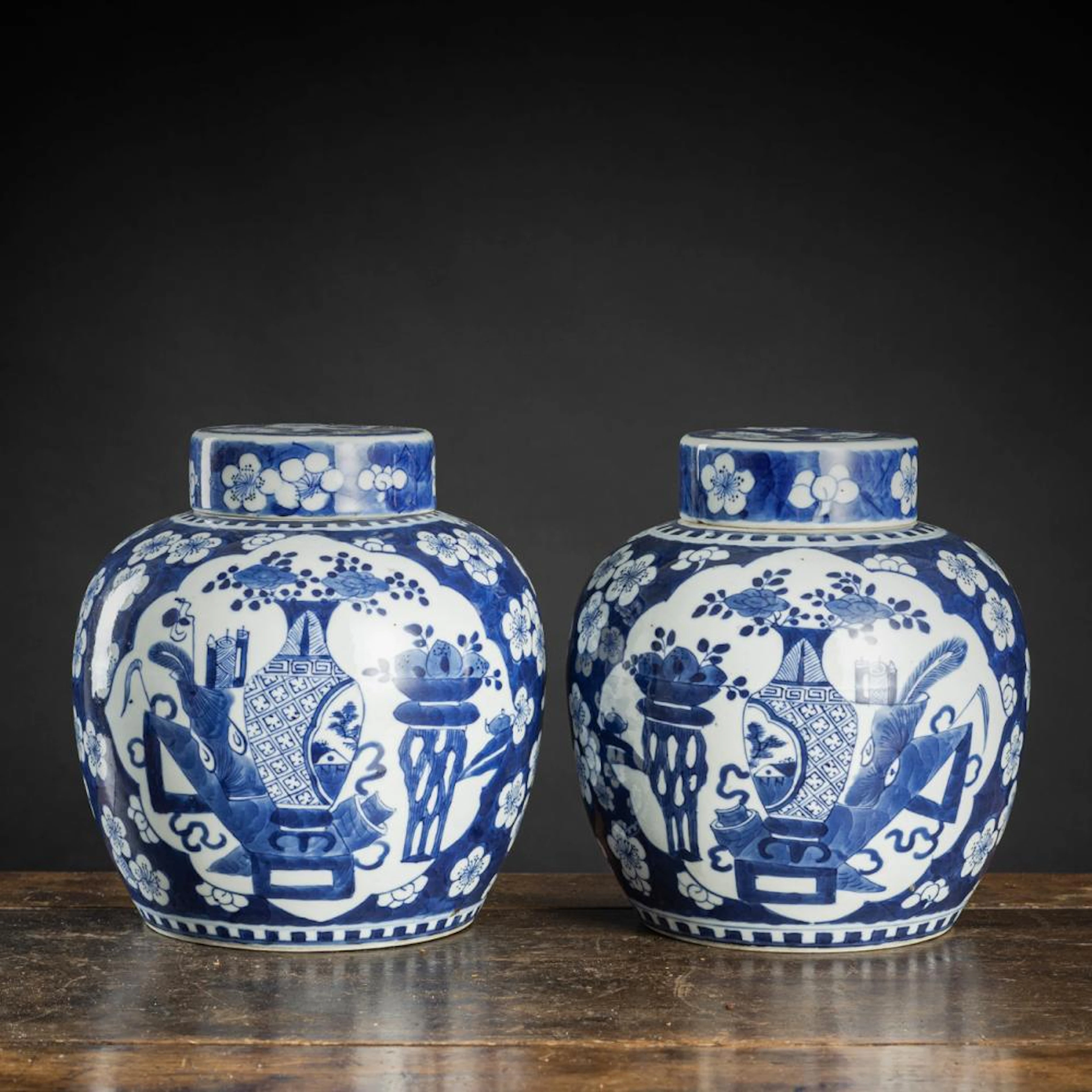 A PAIR OF BLUE AND WHITE PORCELAIN ANTIQUITIES AND PRUNUS VASES AND COVERS