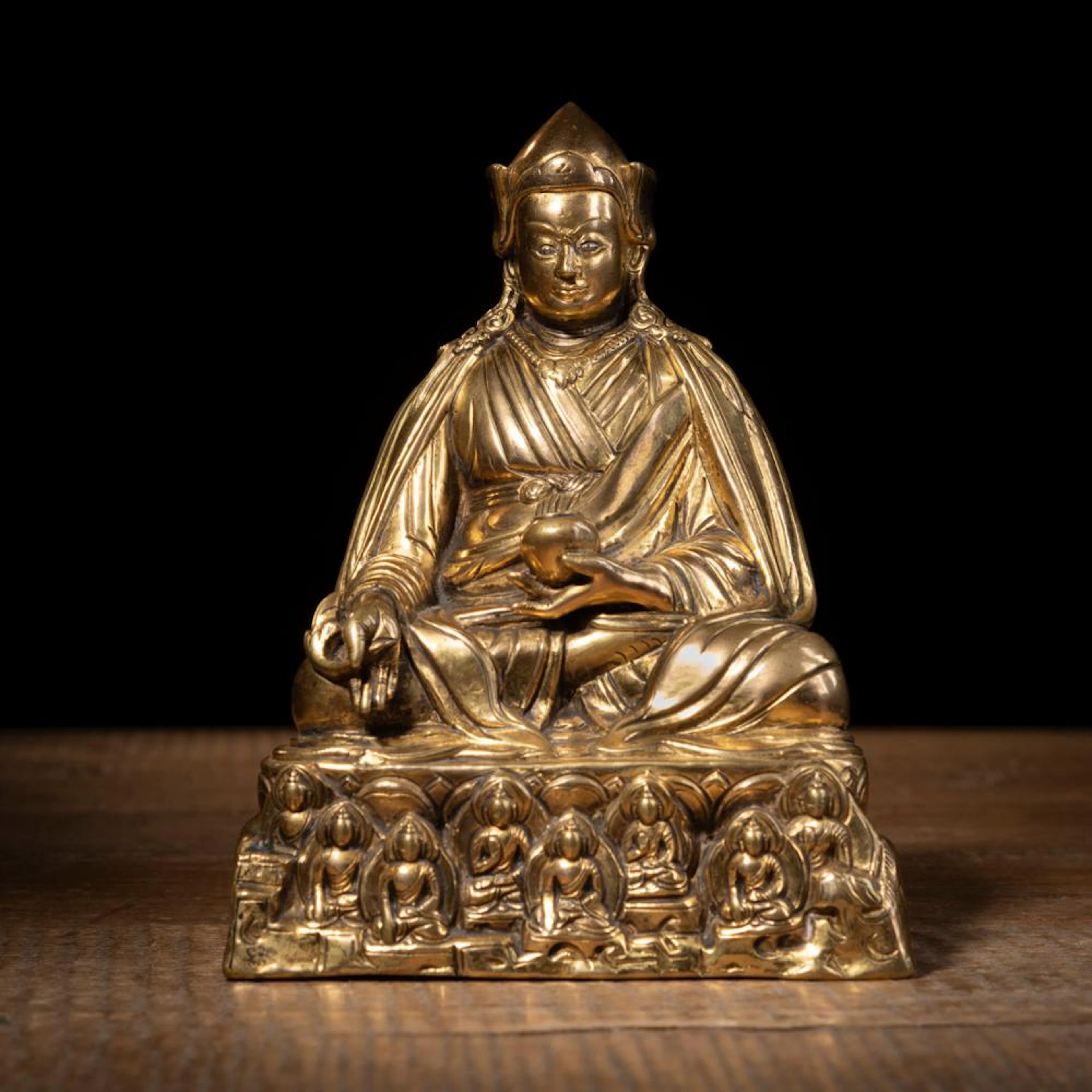 A GILT-BRONZE FIGURE OF A LAMA