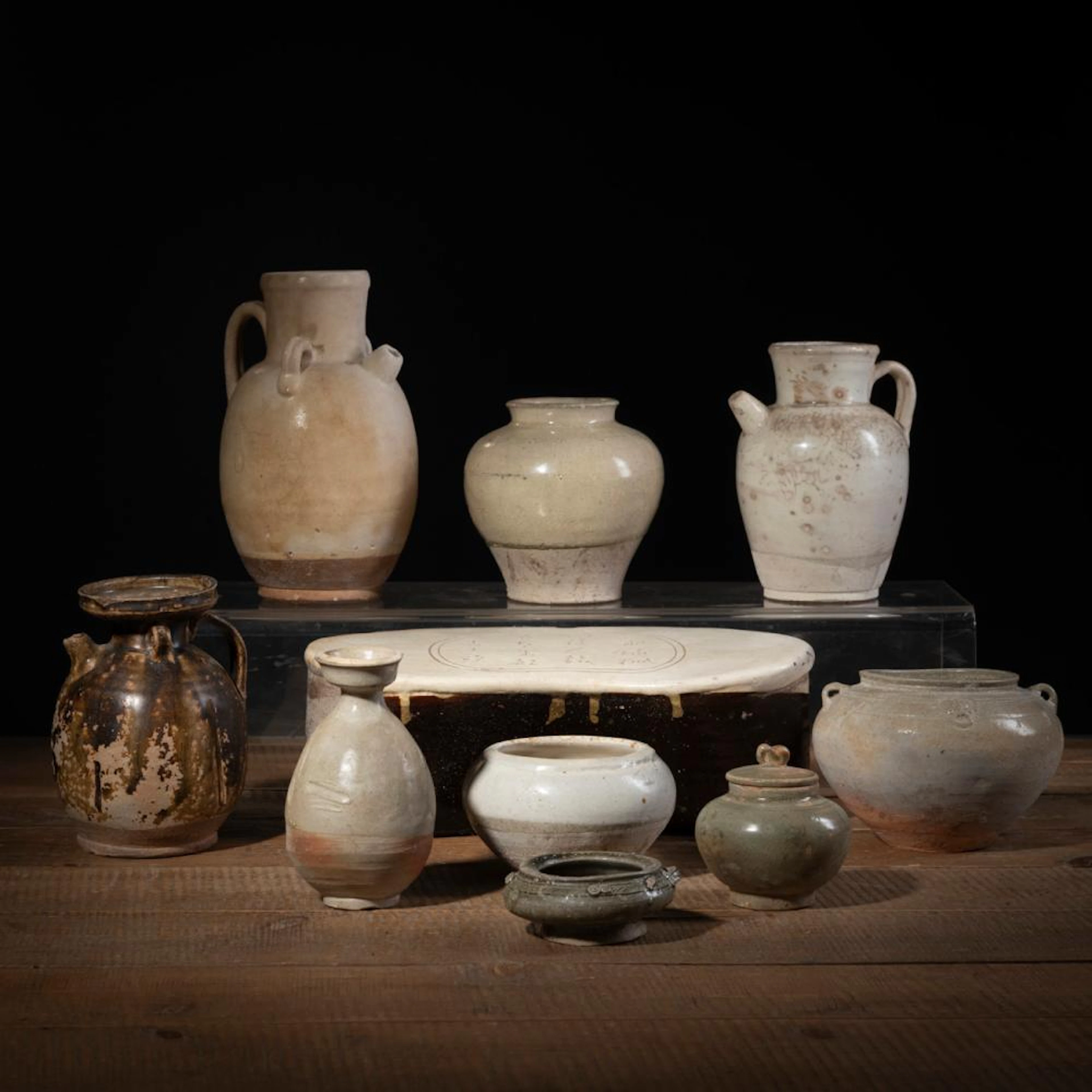 A CERAMIC 'CIZHOU' PILLOW, THREE CREME-GLAZED EWERS, AND FIVE VESSELS