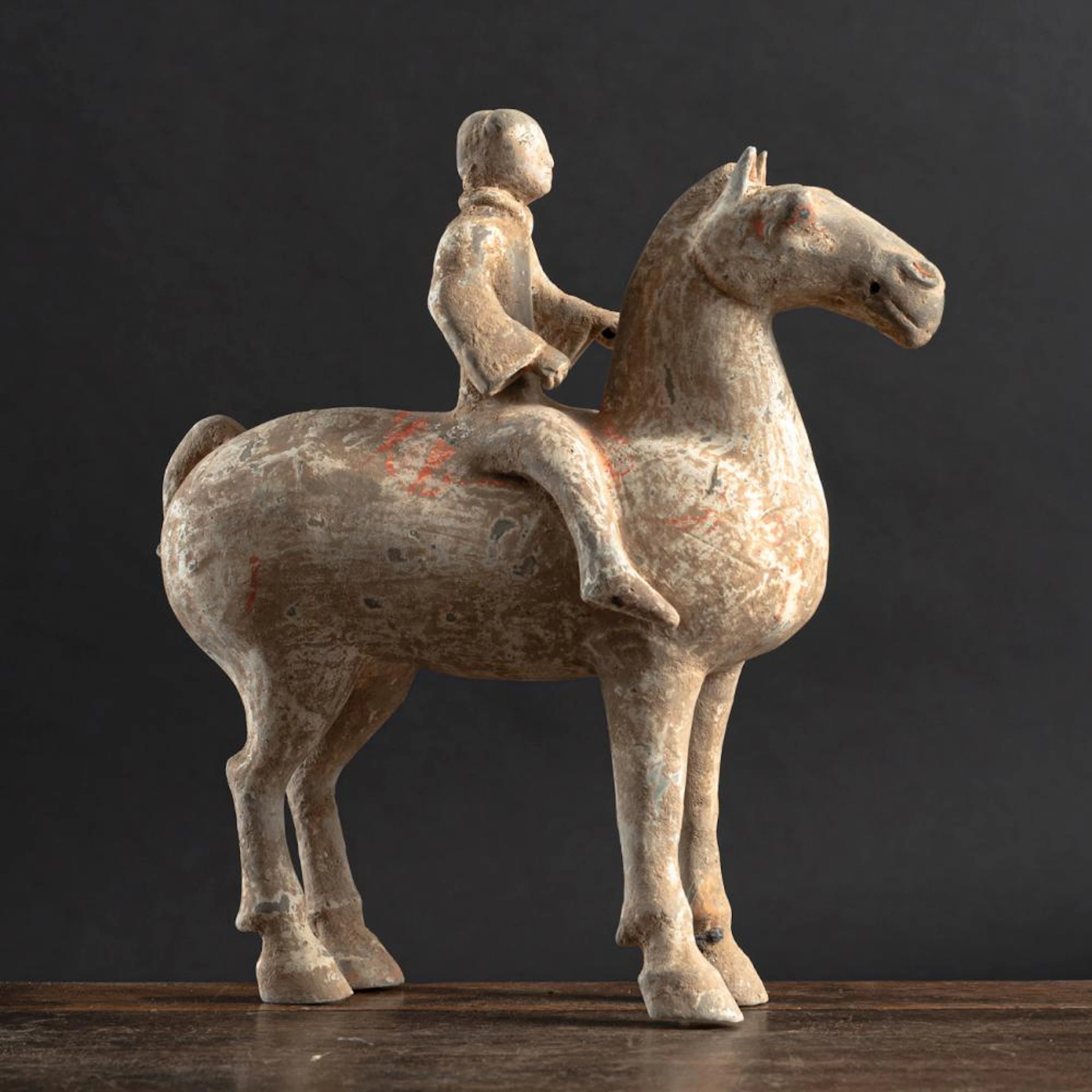 A POTTERY FIGURE OF A MOUNTED HORSE WITH RESIDUE OF POLYCHOME PAINTING