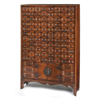 A WOOD APOTHECARY CABINET WITH INCRIBED DRAWERS AND METAL MOUNTS