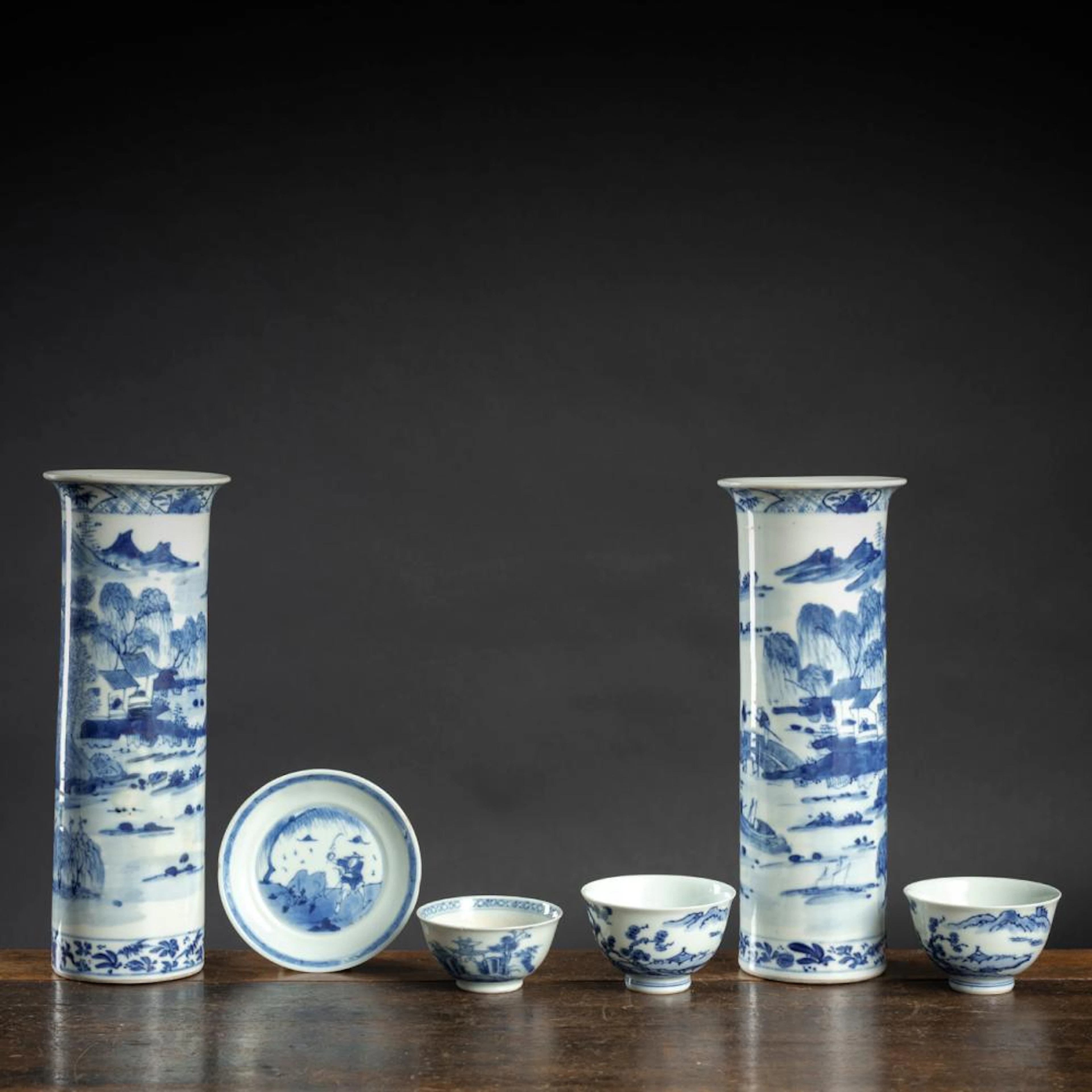 TWO CYLINDRICAL BLUE AND WHITE PORCELAIN VASES, THREE CUPS, AND A SAUCER