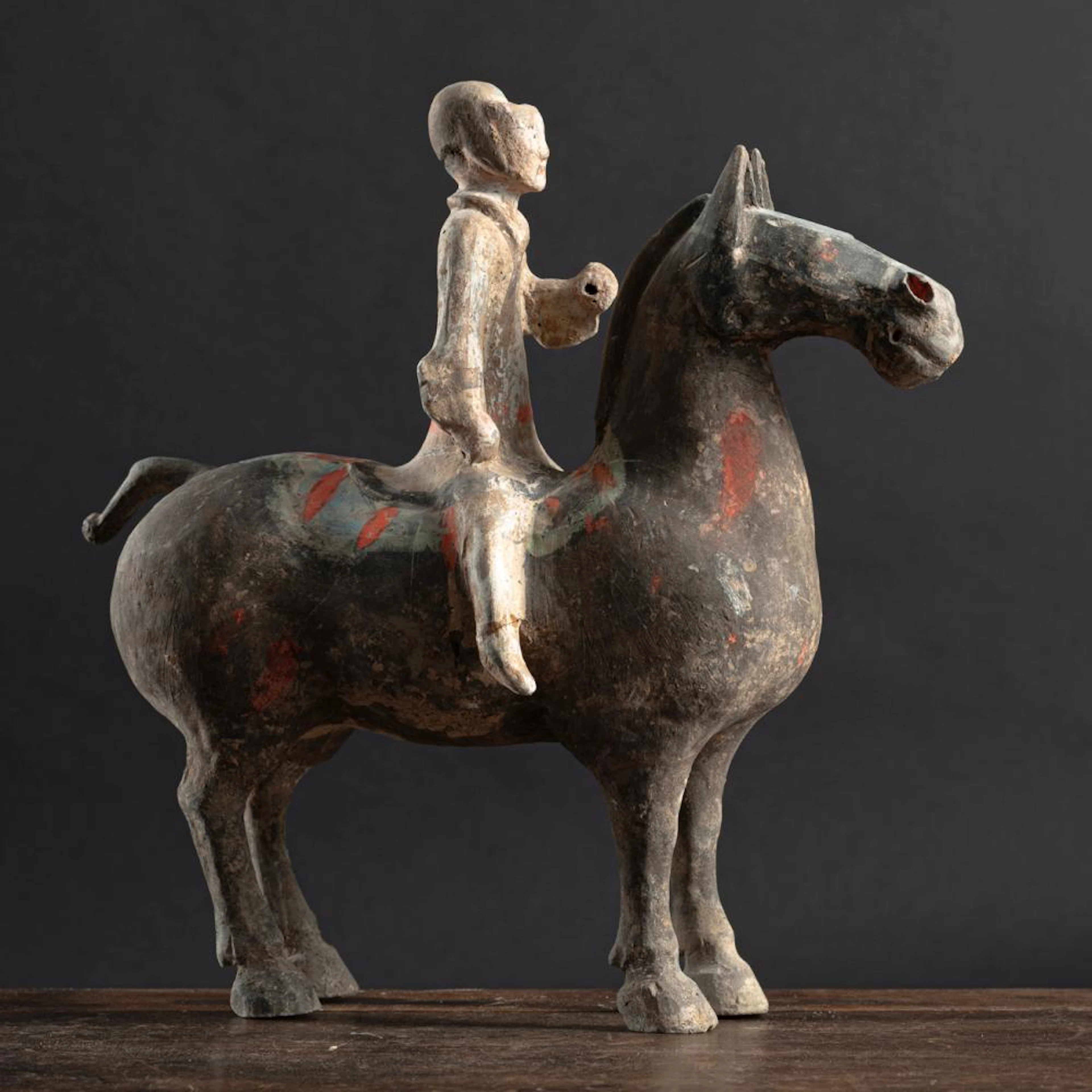 A POLYCHROME PAINTED POTTERY FIGURE OF A MOUNTED HORSE