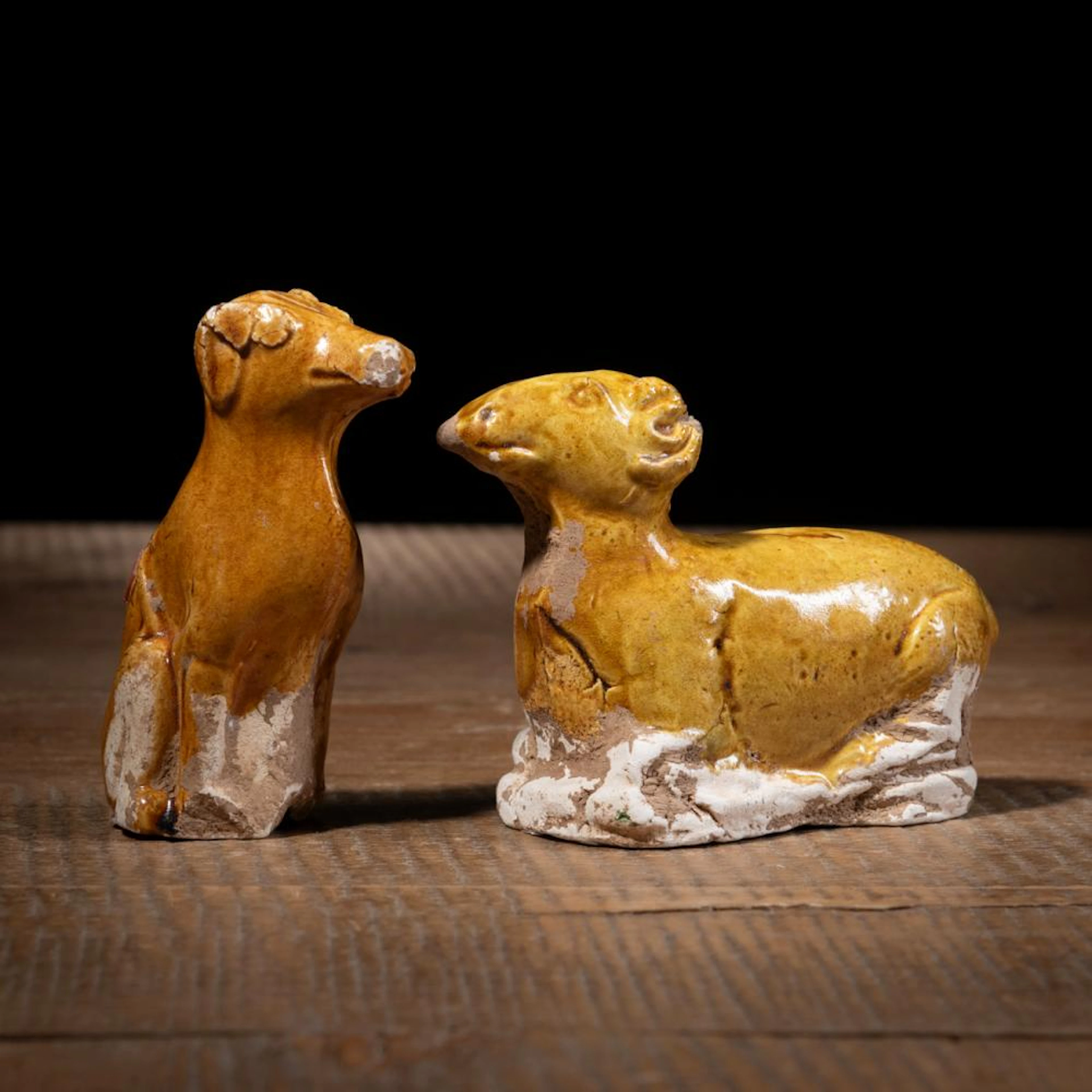 TWO AMBER-GLAZED POTTERY FIGURES OF A DOG AND A RAM