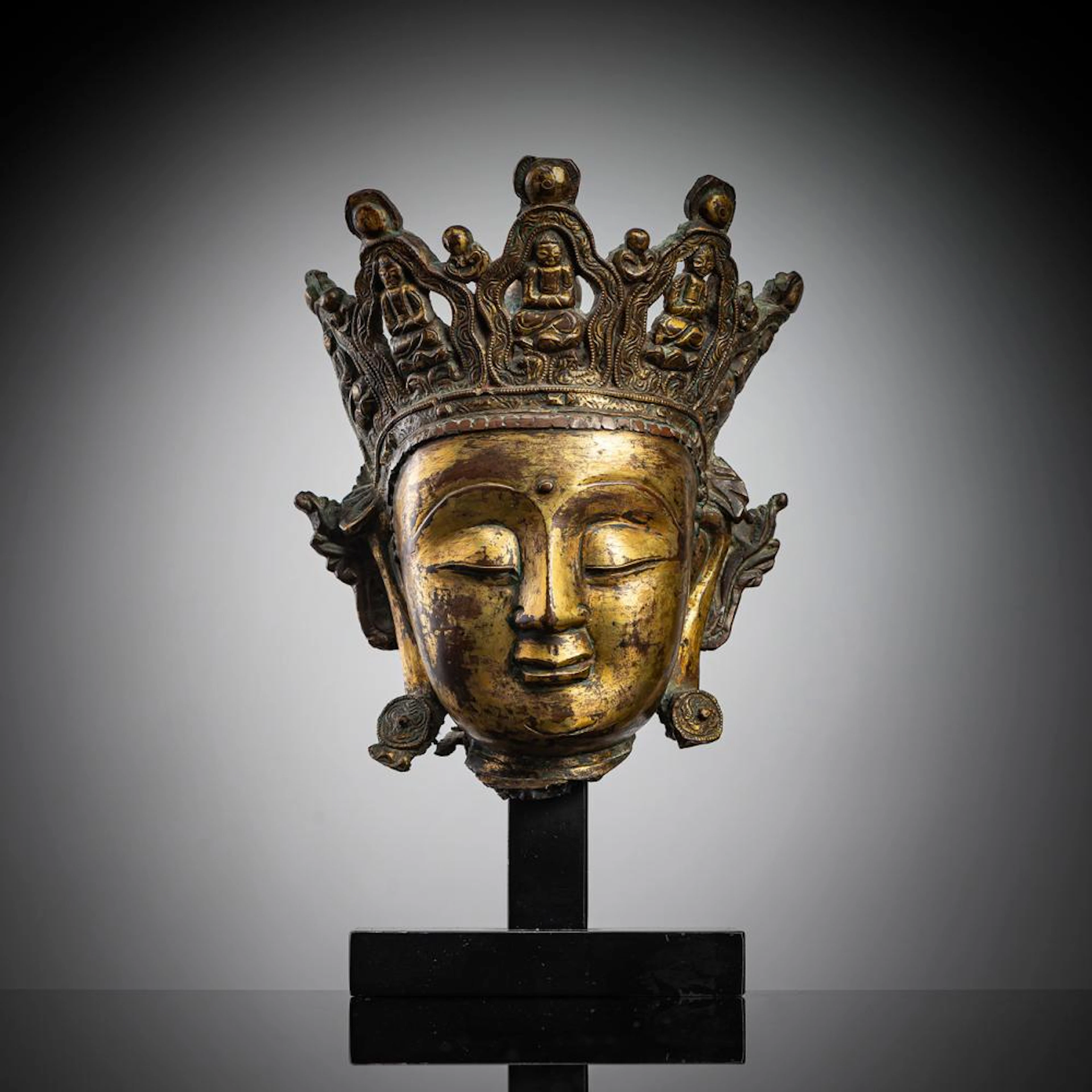 A GILT-BRONZE HEAD OF CROWNED BUDDHA