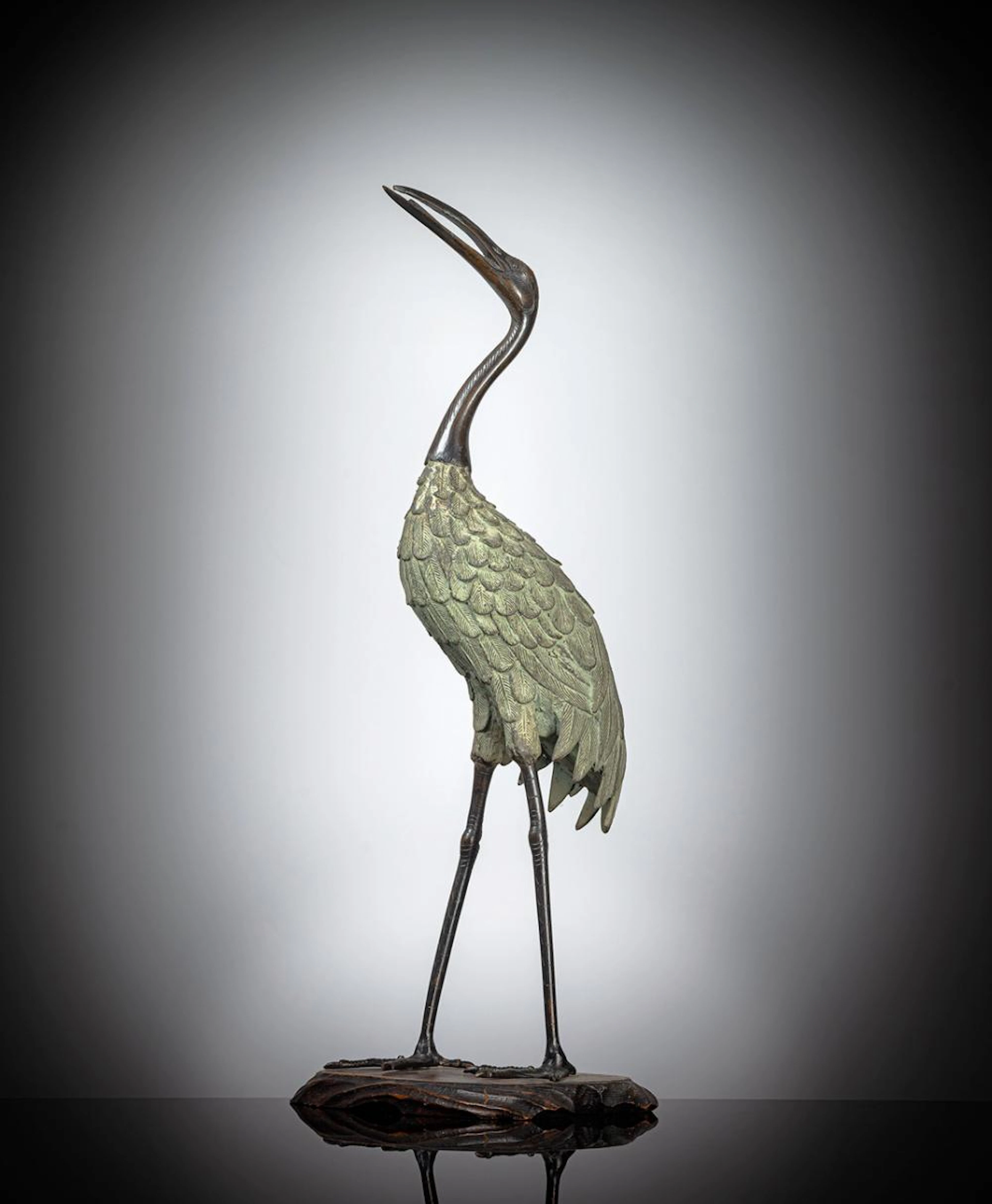 A BRONZE SCULPTURE OF A STANDING CRANE