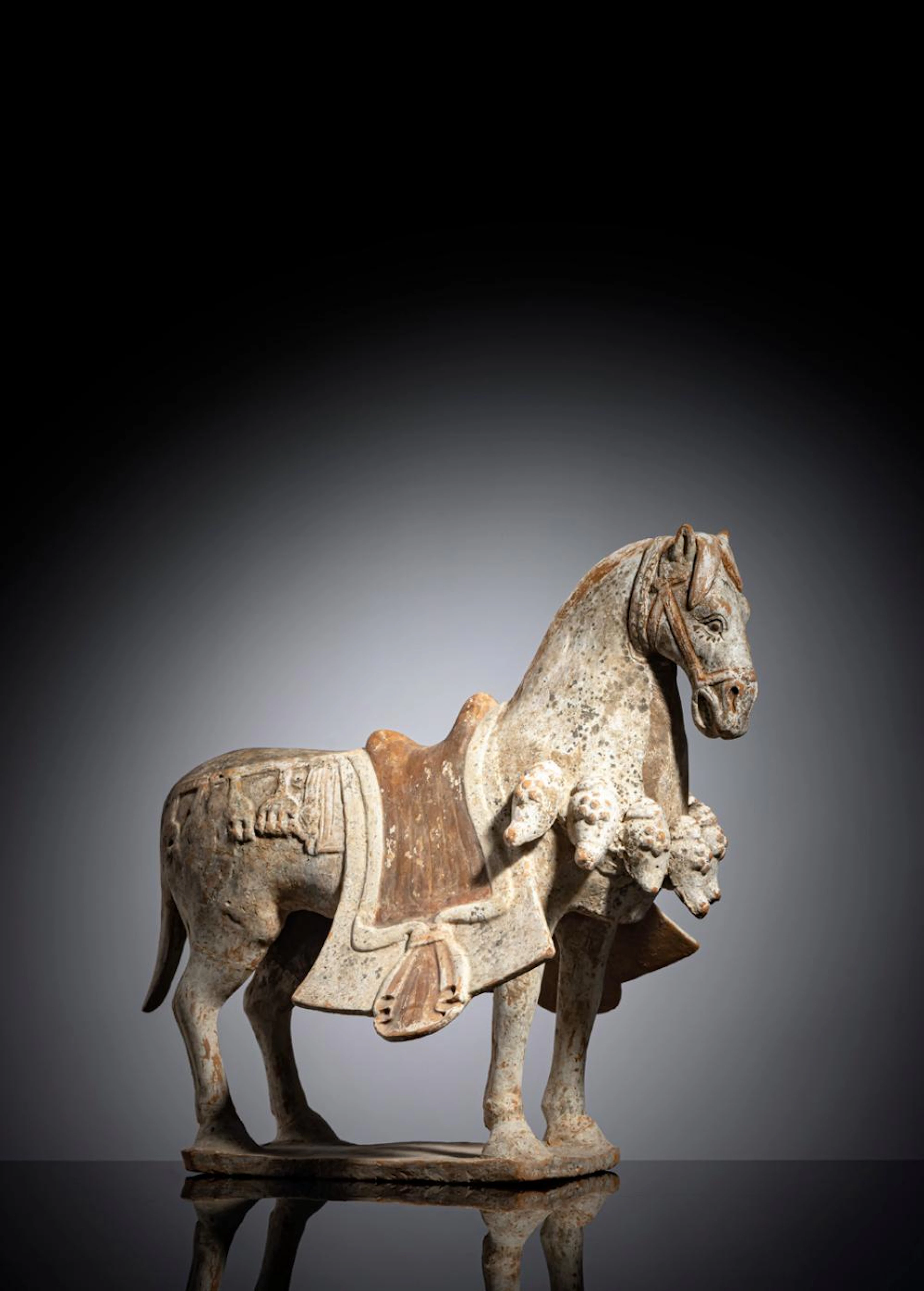 A POTTERY MODEL OF A CAPARISONED HORSE