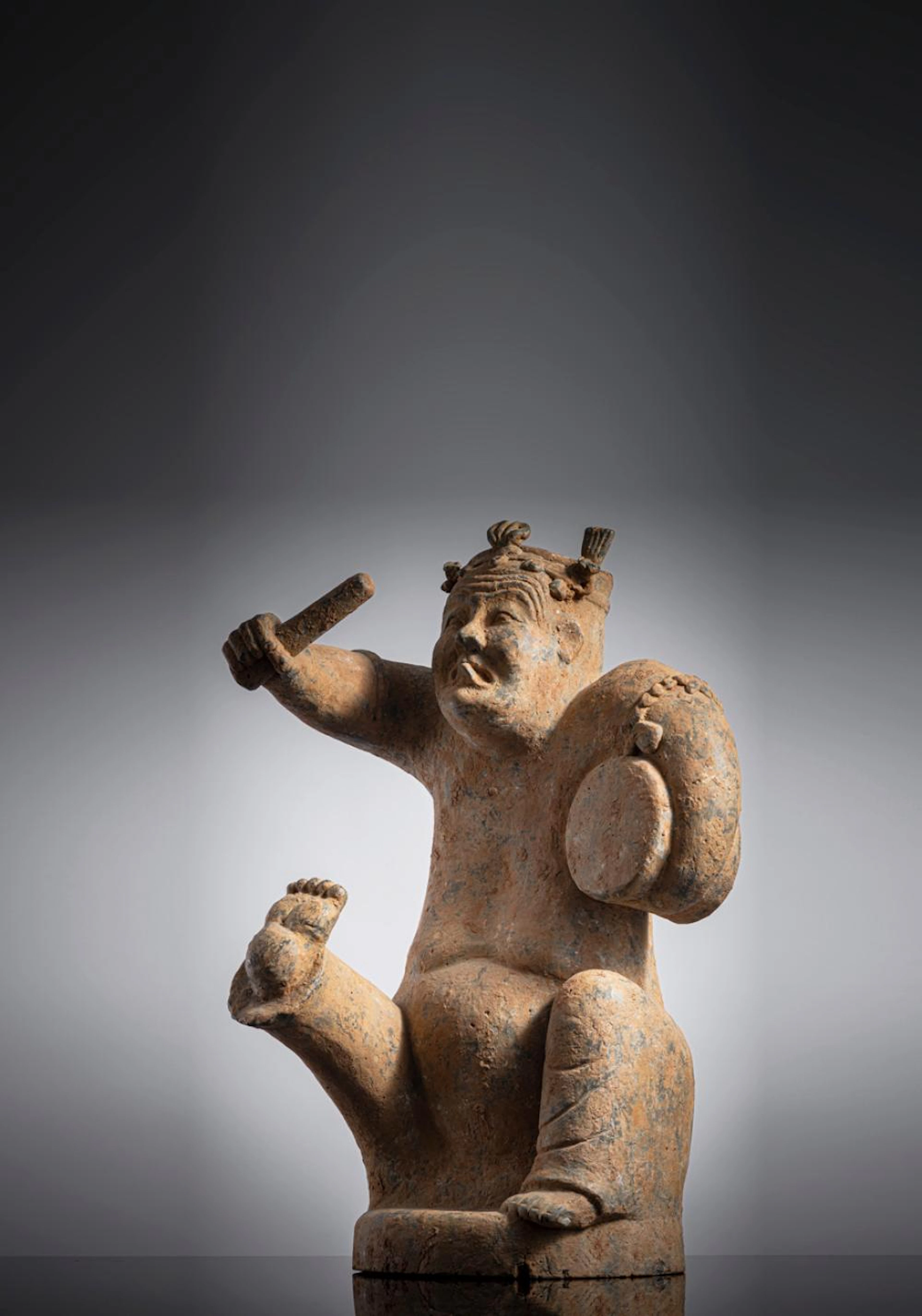 A PAINTED POTTERY FIGURE OF A DRUMMER