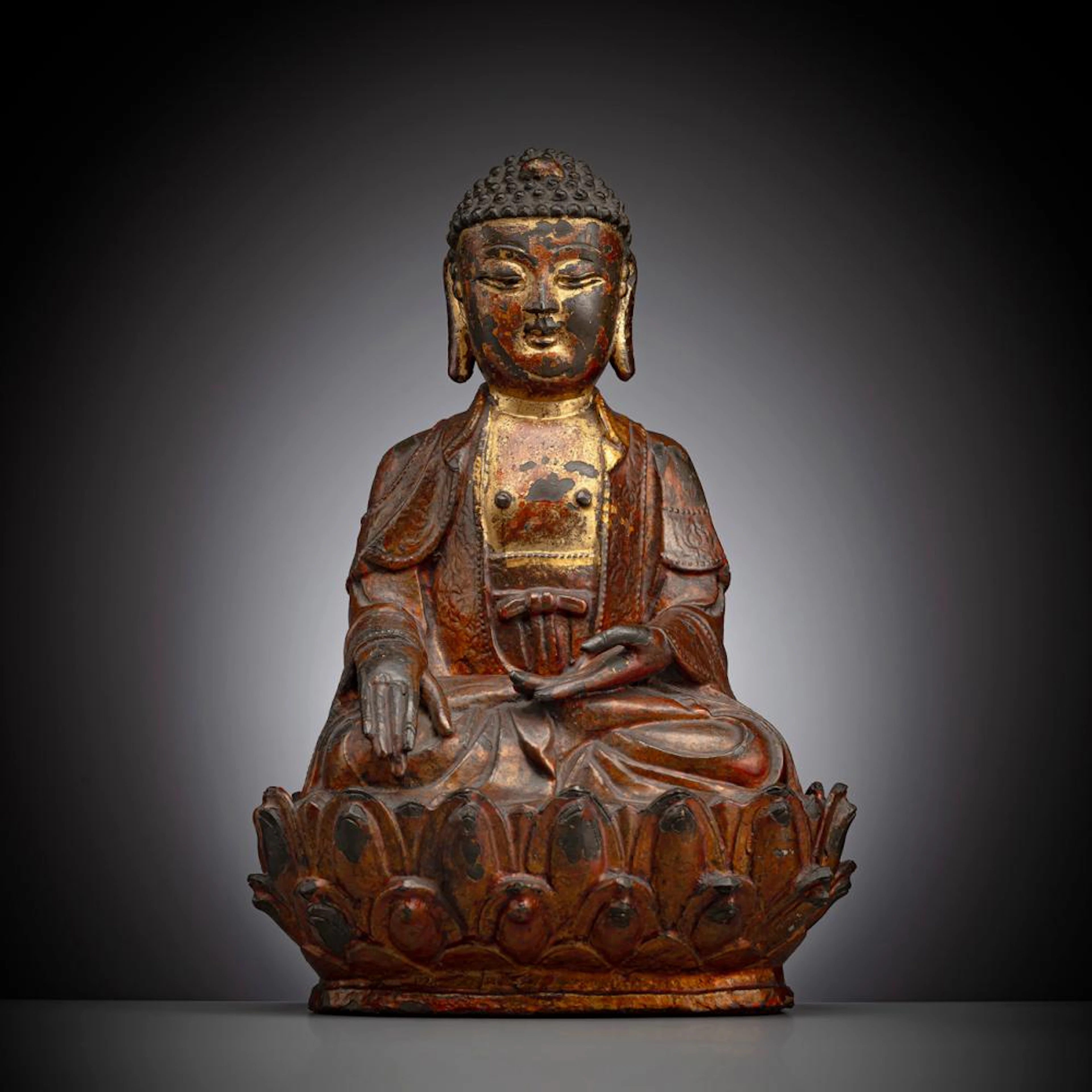 A GILT-LACQUERED BRONZE FIGURE OF BUDDHA SHAKYAMUNI ON A LOTUS