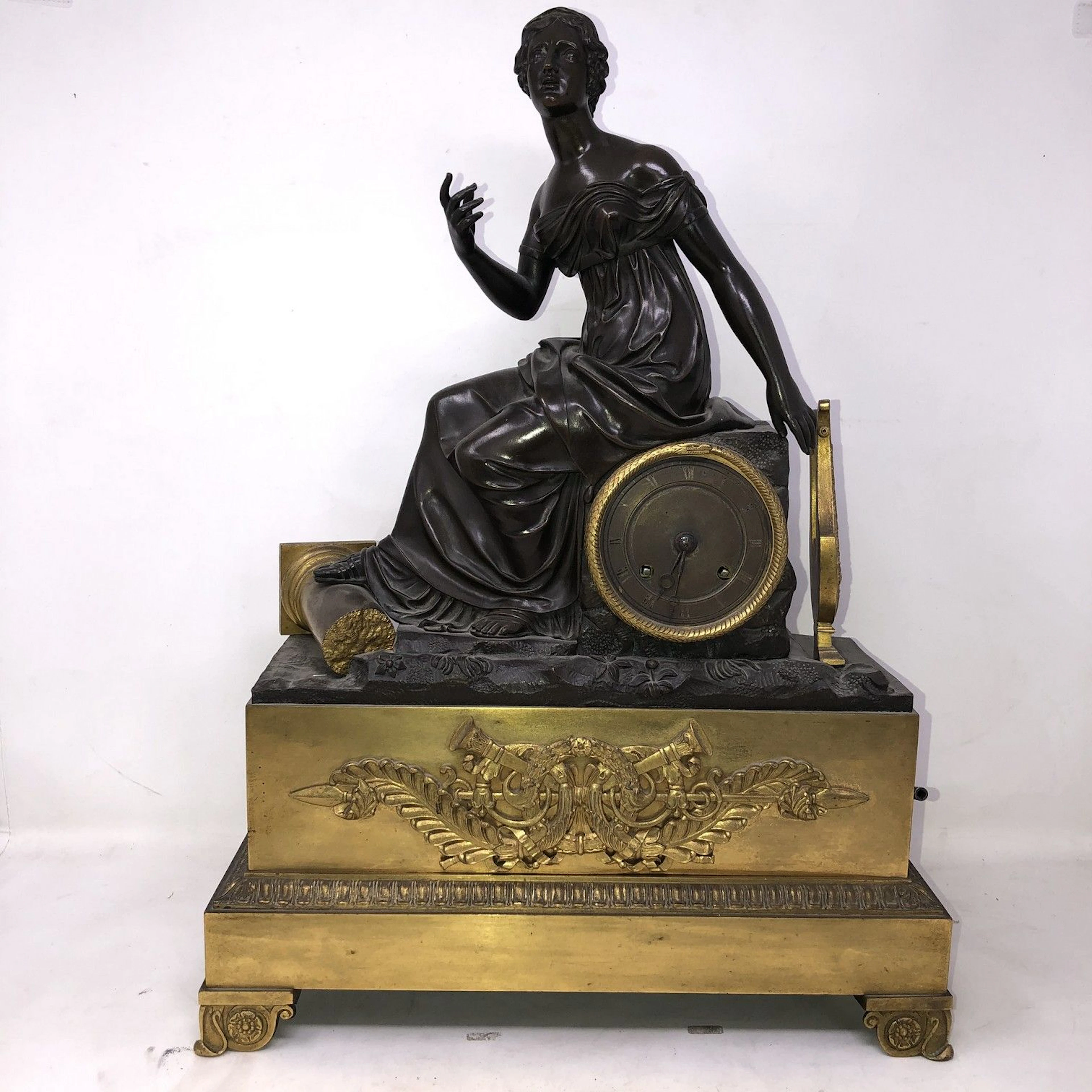 Pendule en bronze doré et patiné "Femme à..
