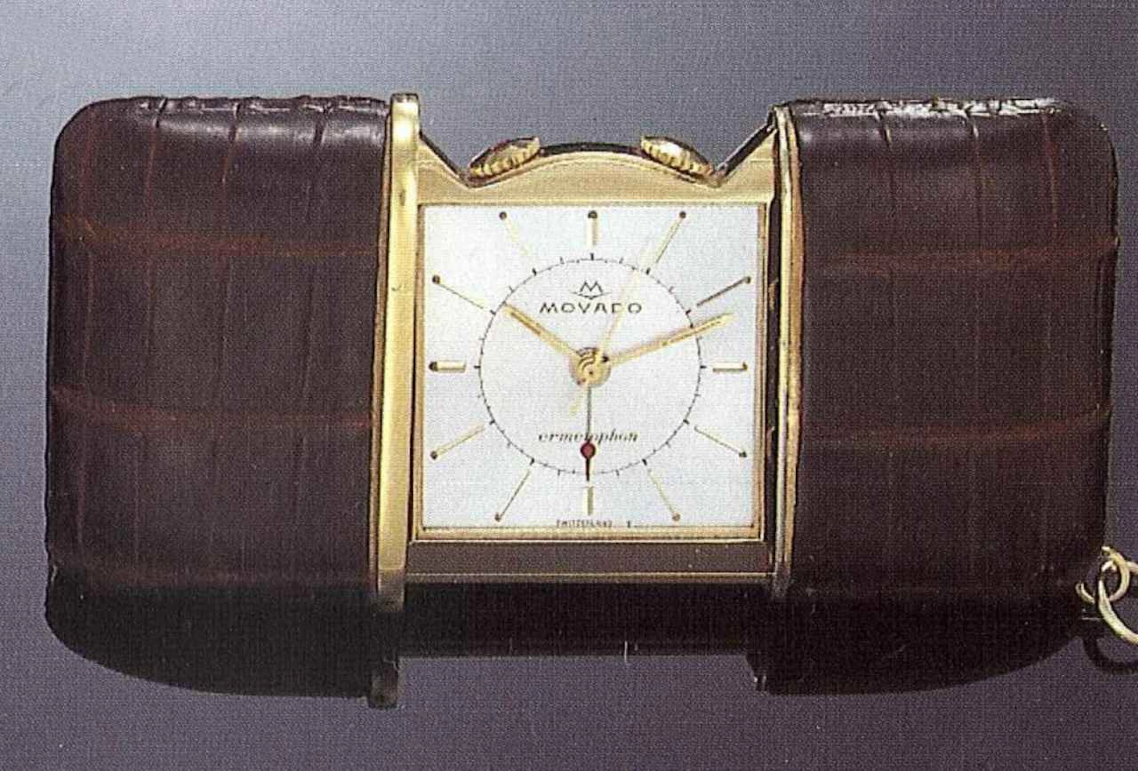 Movado, "Ermetophon", Switzerland, anni '50. Interessante orologio da borsetta, in metallo dorato, ricoperto in pelle, a carica automatica e sveglia.