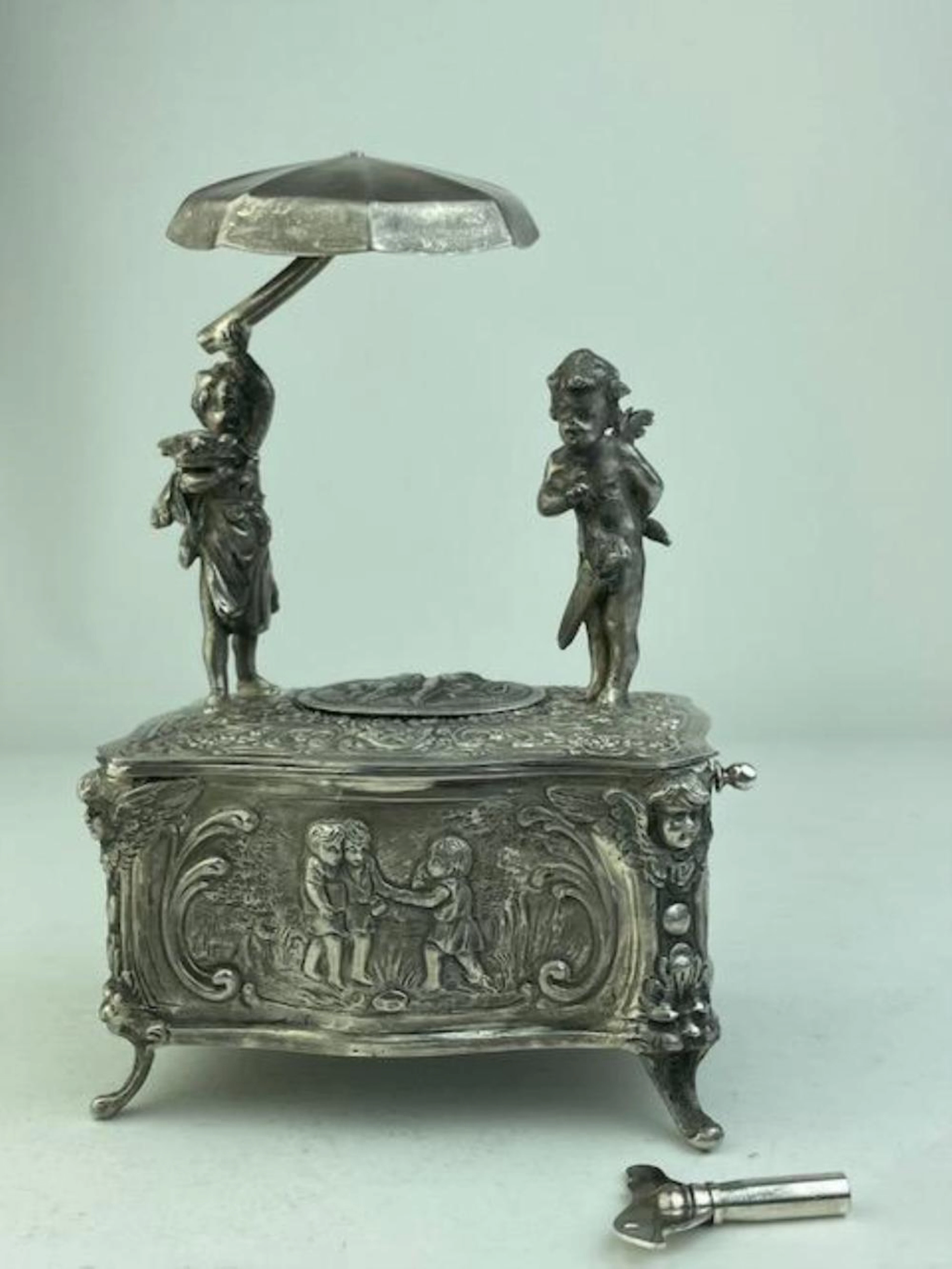 Mechanical singing bird box automaton with a young boy and girl with an umbrella