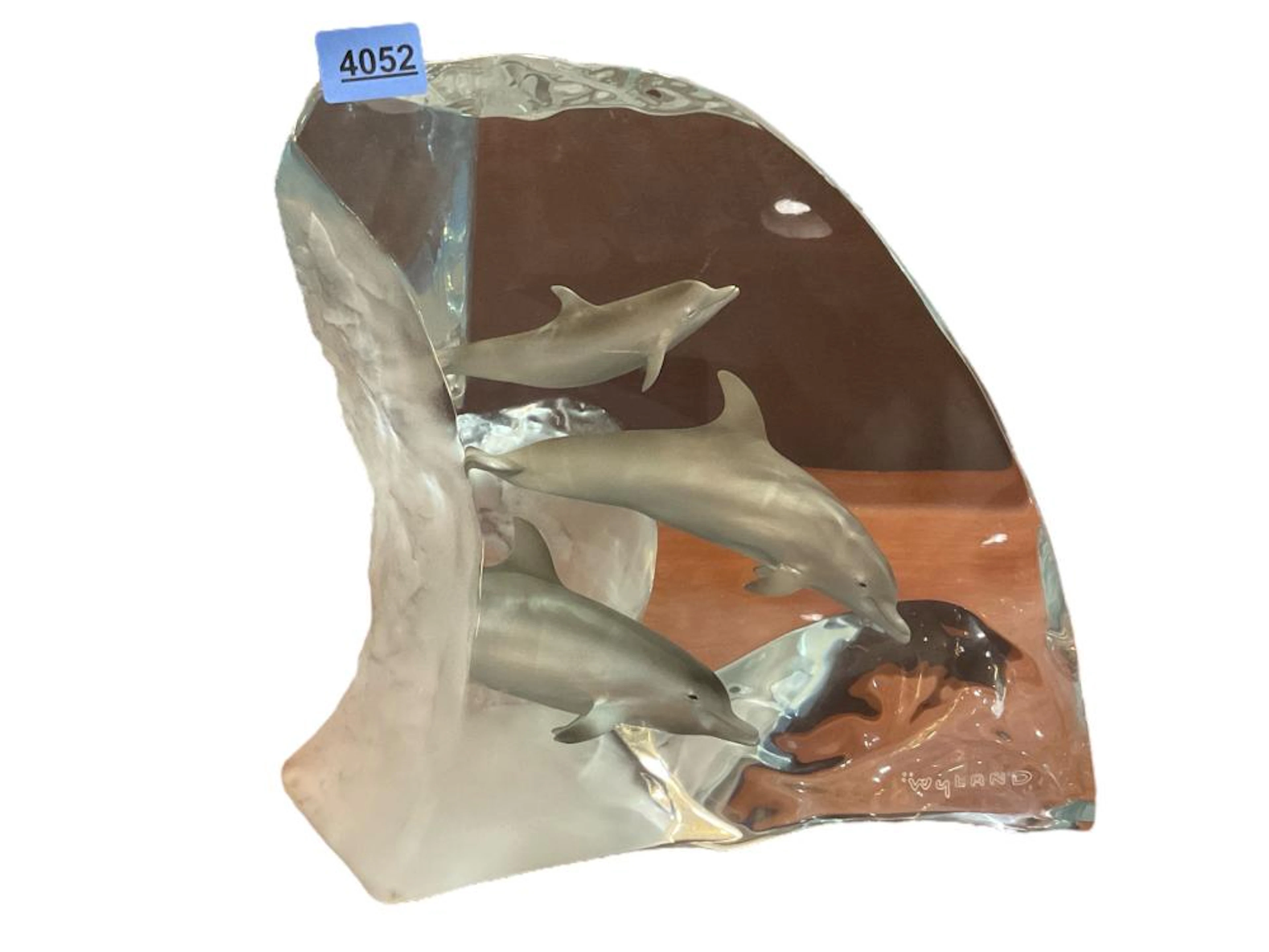 Contemporary lucite sculpture with dolphins signed Wyland. 12? tall.