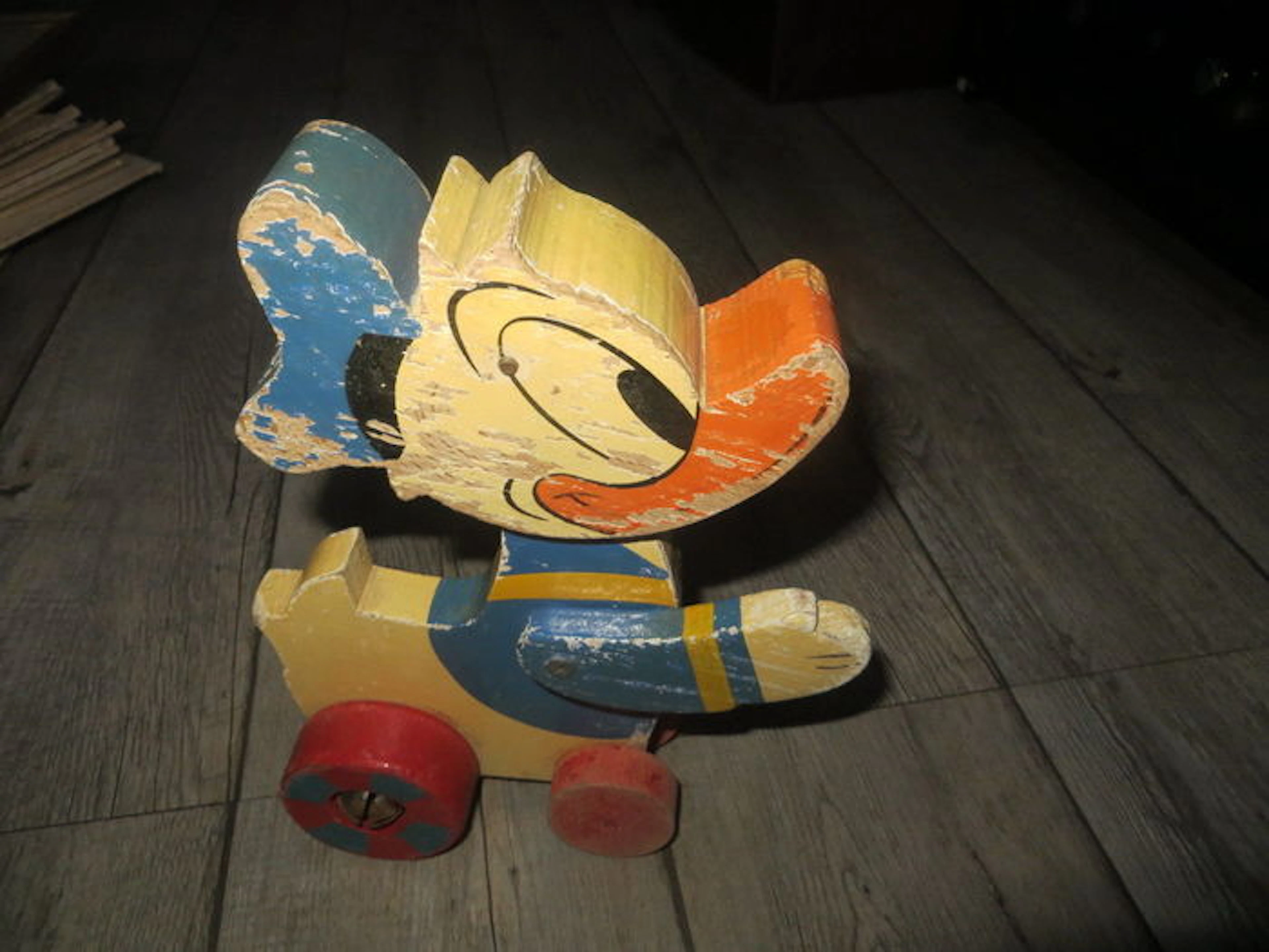 Ancien jouet a tirer-Donald en bois sur roulette- tete mobile-grelot(1930-1940)