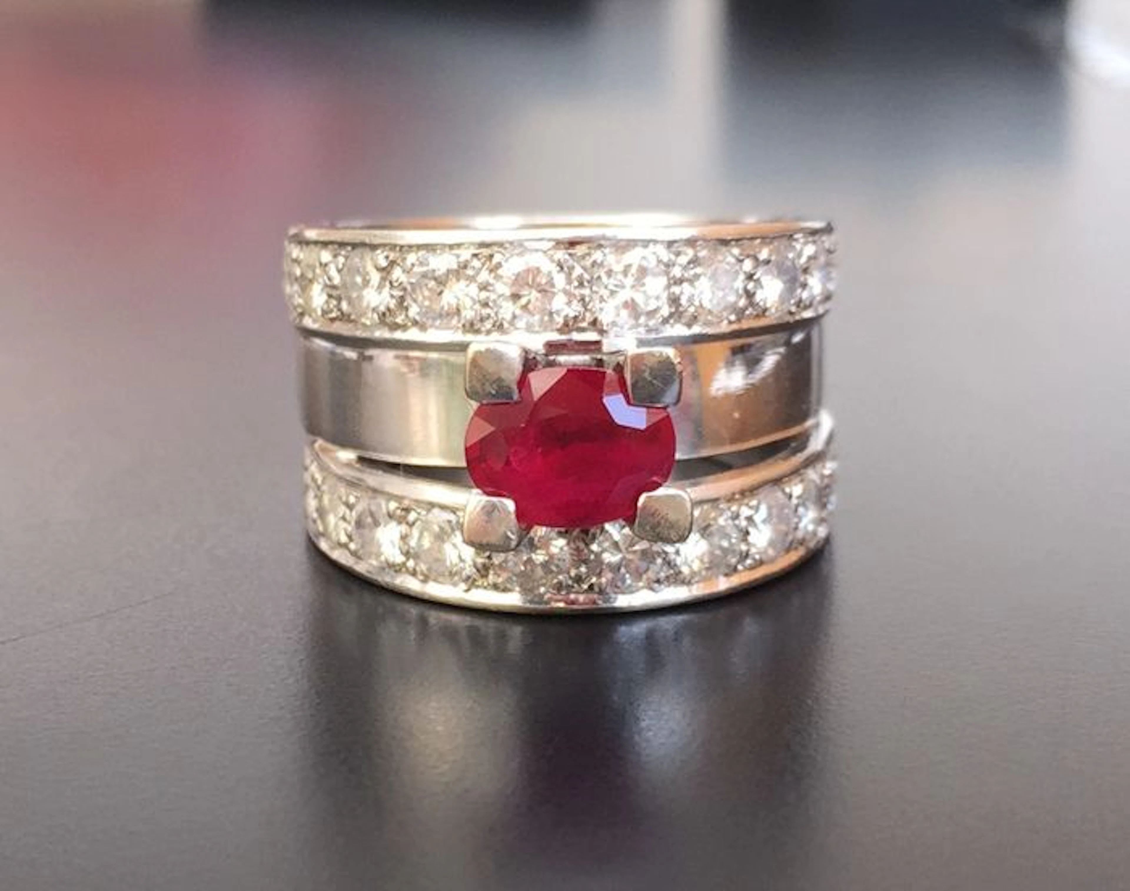 Contemporary ring in 18 kt white gold with a central oval pigeon's blood ruby, 1.2 ct, lined with 2 ct of diamonds