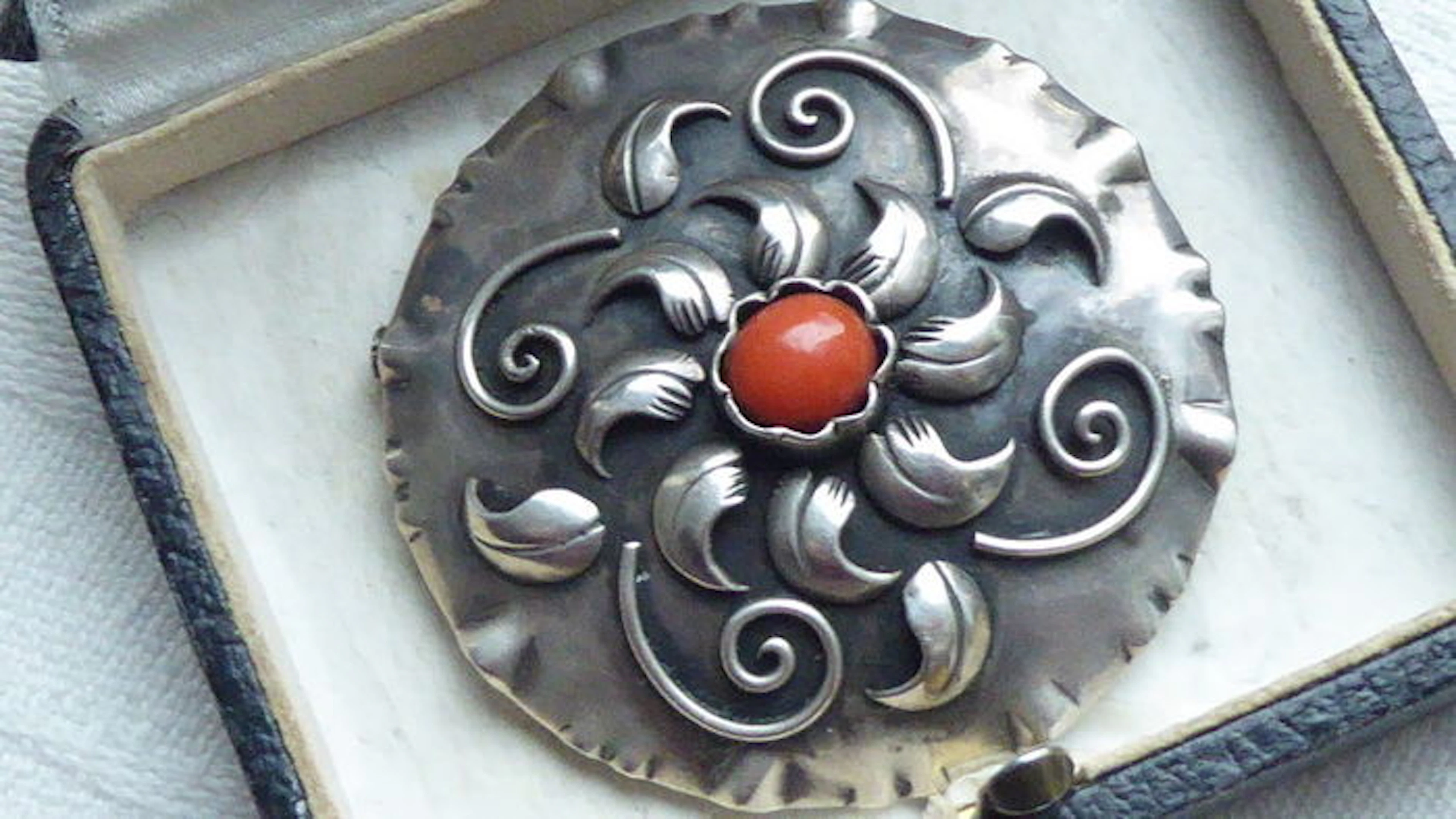 Round antique silver brooch with a natural red coral