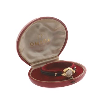 OMEGA: A LADIES 18 CARAT GOLD CASED WRIST WATCH.