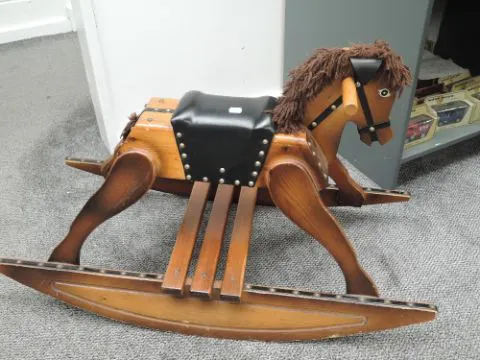 A traditional wooden Rocking Horse having leather seat on rocker base ...