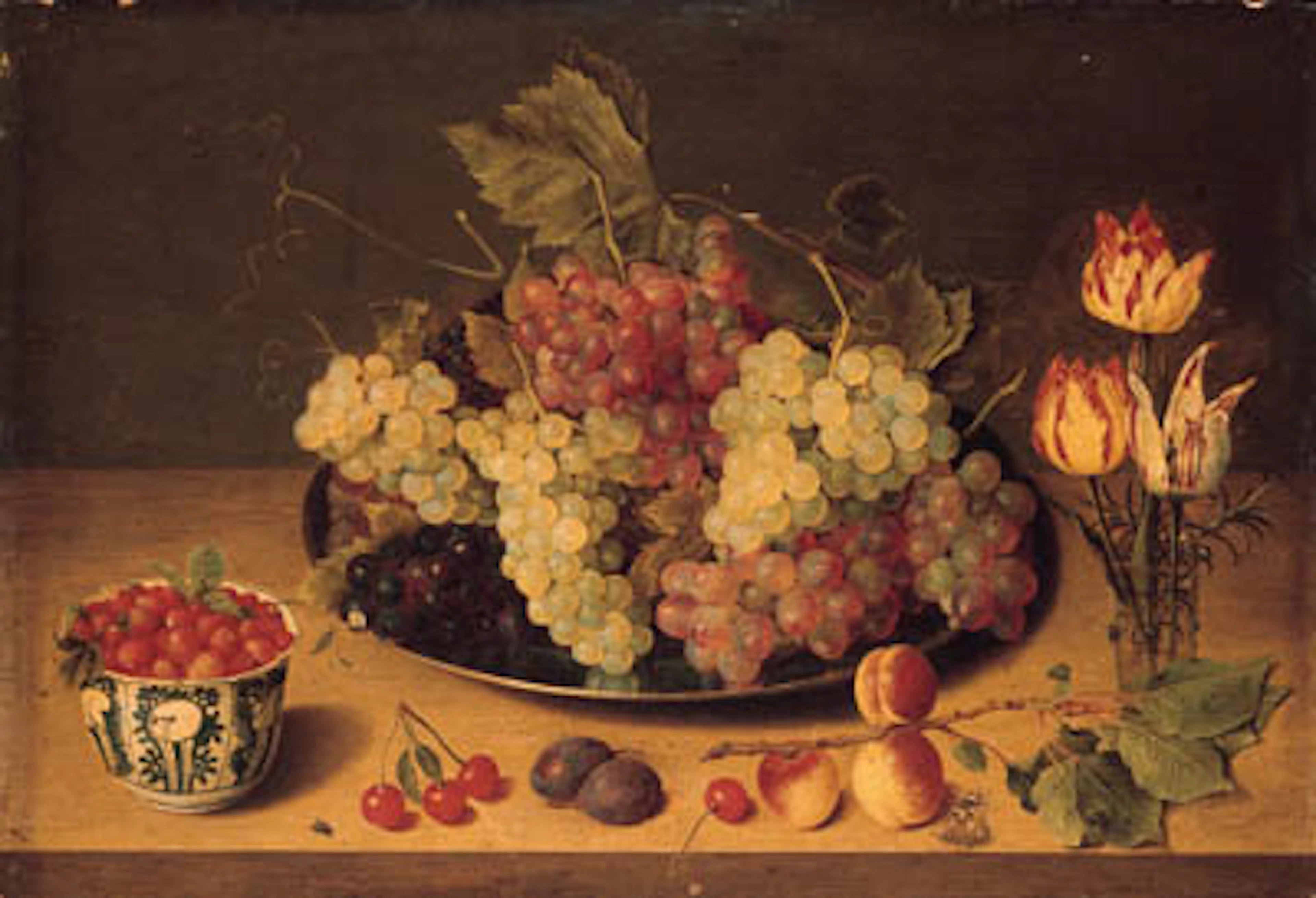 Bunches of grapes and vine leaves on a pewter platter, parrot tulips in a glass, wild strawberries in a Wanli kraak porselein bowl, plums, cherries, a fly, a