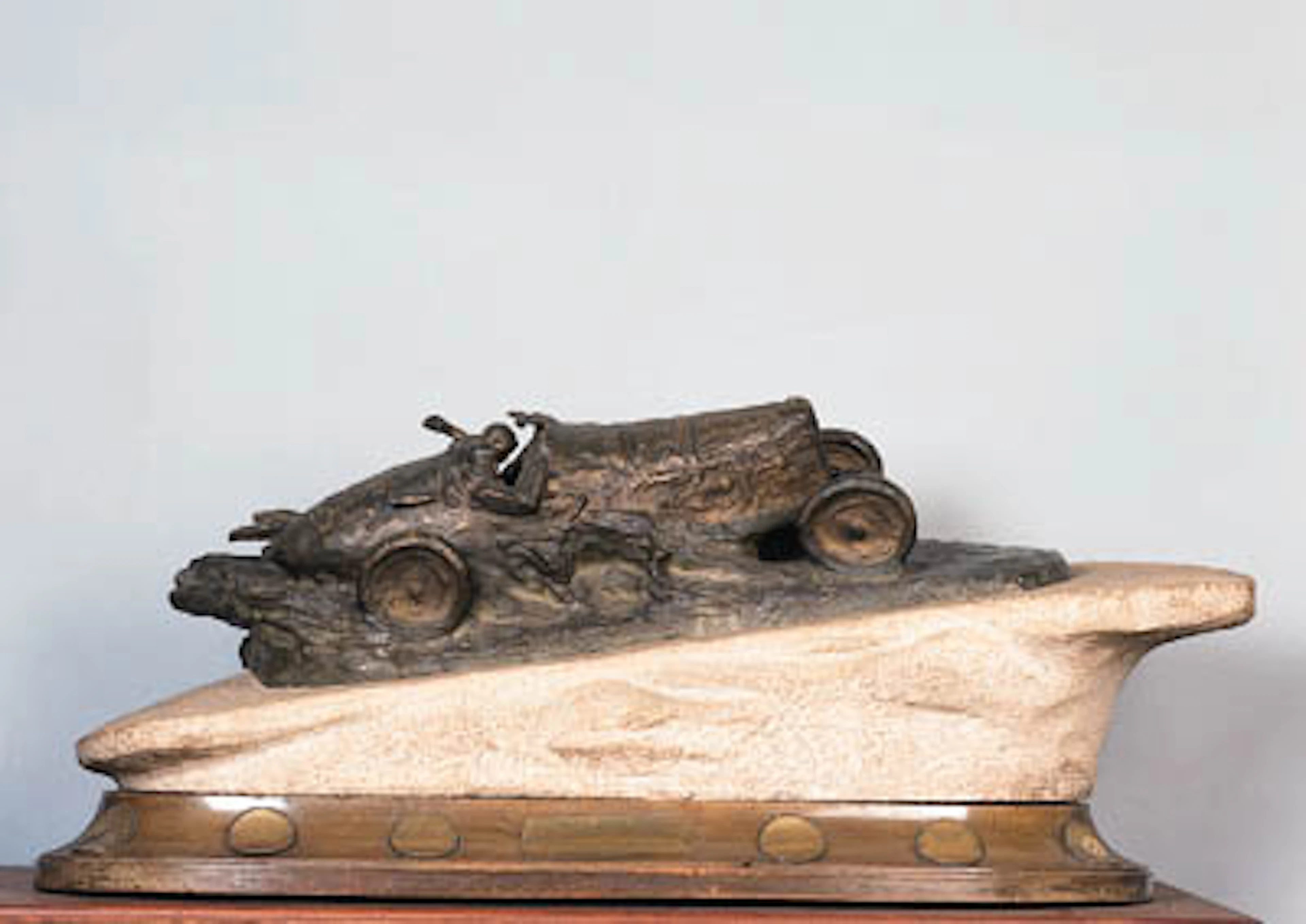 After P. DE SOETE "Vers la Victoire" - an original sculpture depicting early race-car hillclimbing; well-detailed cast bronze, surmounting carved stone landscape base, mounted upon a wood plinth